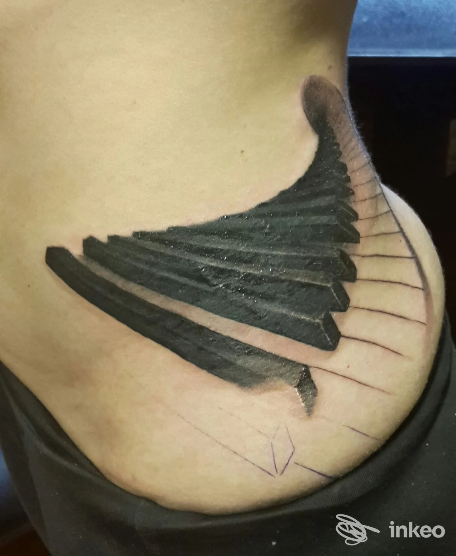 Tatuaggio blackwork a forma di ala sul fianco, foto inviata dallo studio VentoForato Imperia, Imperia.