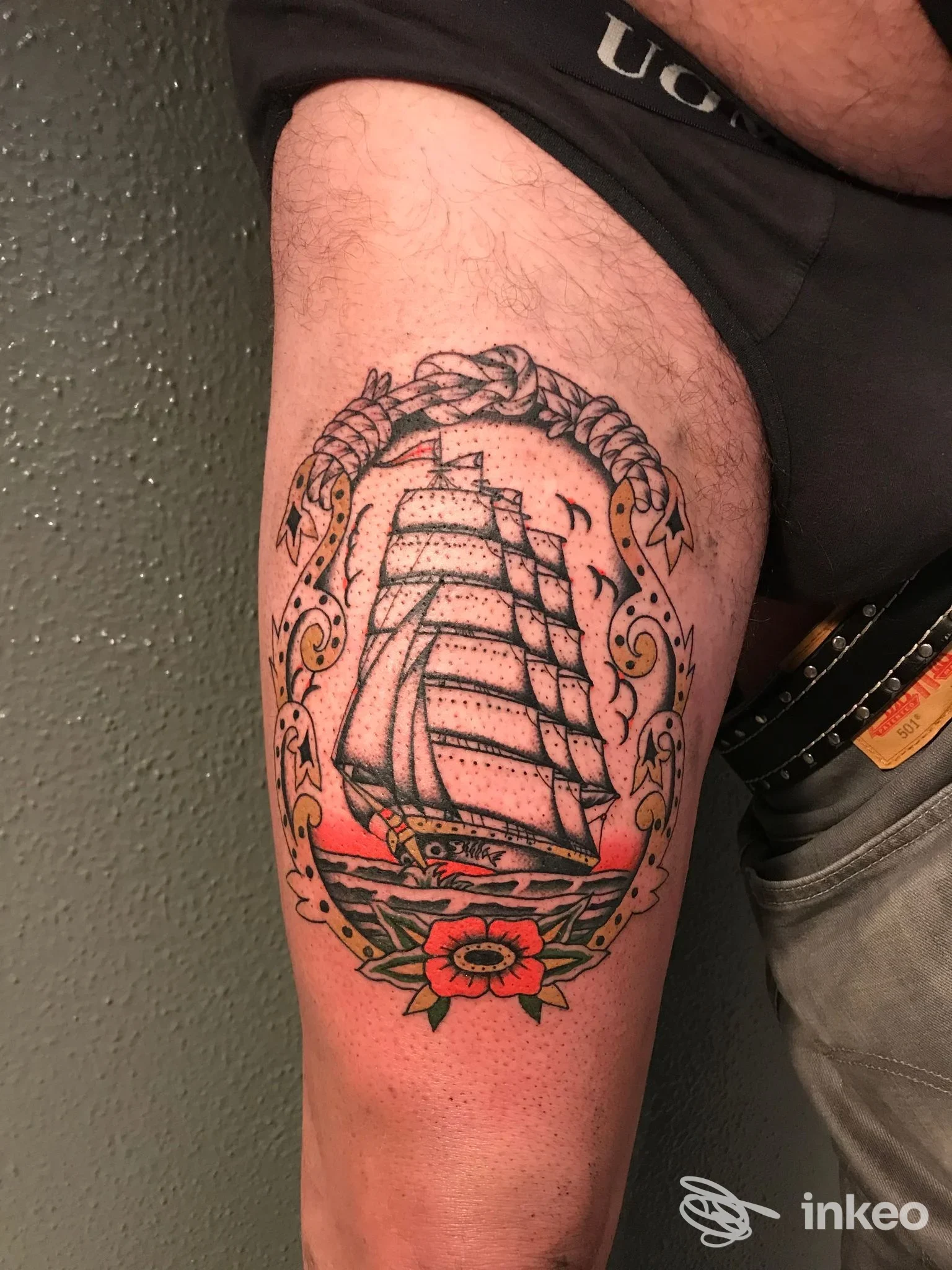 Tatuaggio tradizionale su coscia con nave a vele e ornamento floreale, Old bones, Cogoleto.