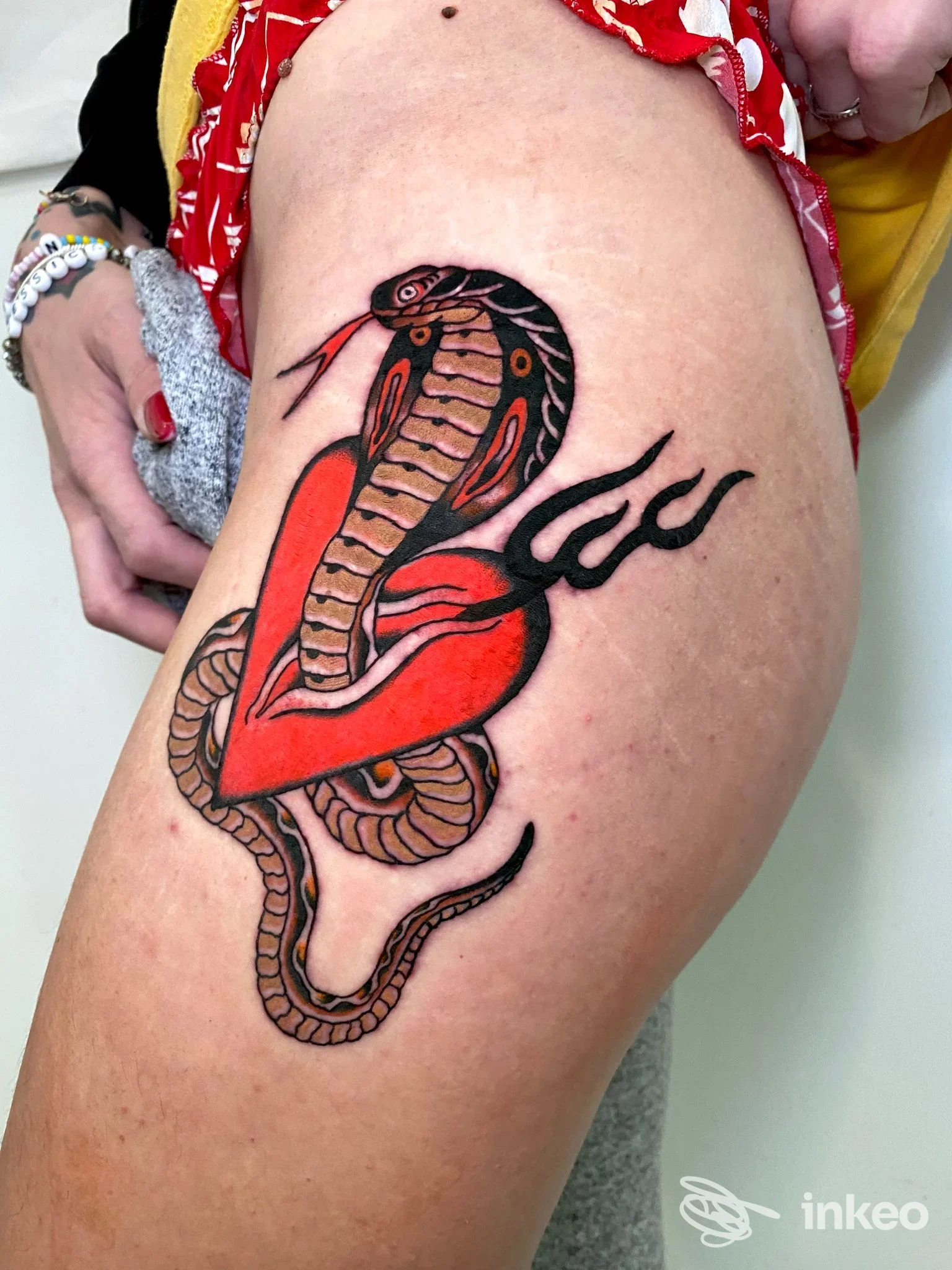 Tatuaggio cobra e cuore rosso sulla coscia, Lighthouse Factory, Pisa.