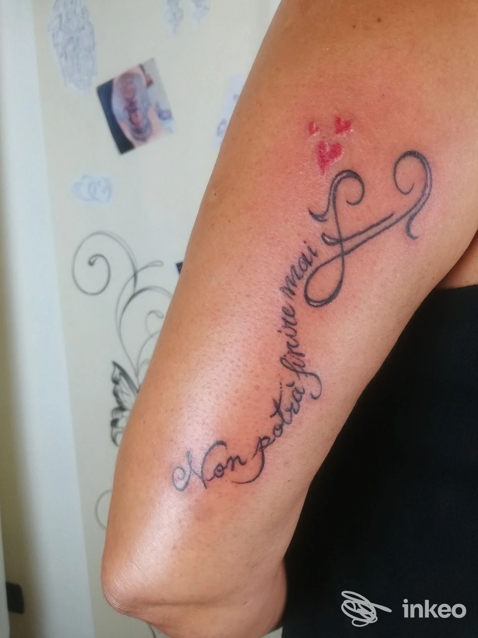 Tatuaggio calligrafico sul braccio con tre piccoli cuori rossi, Sararte Atelier, Genova.