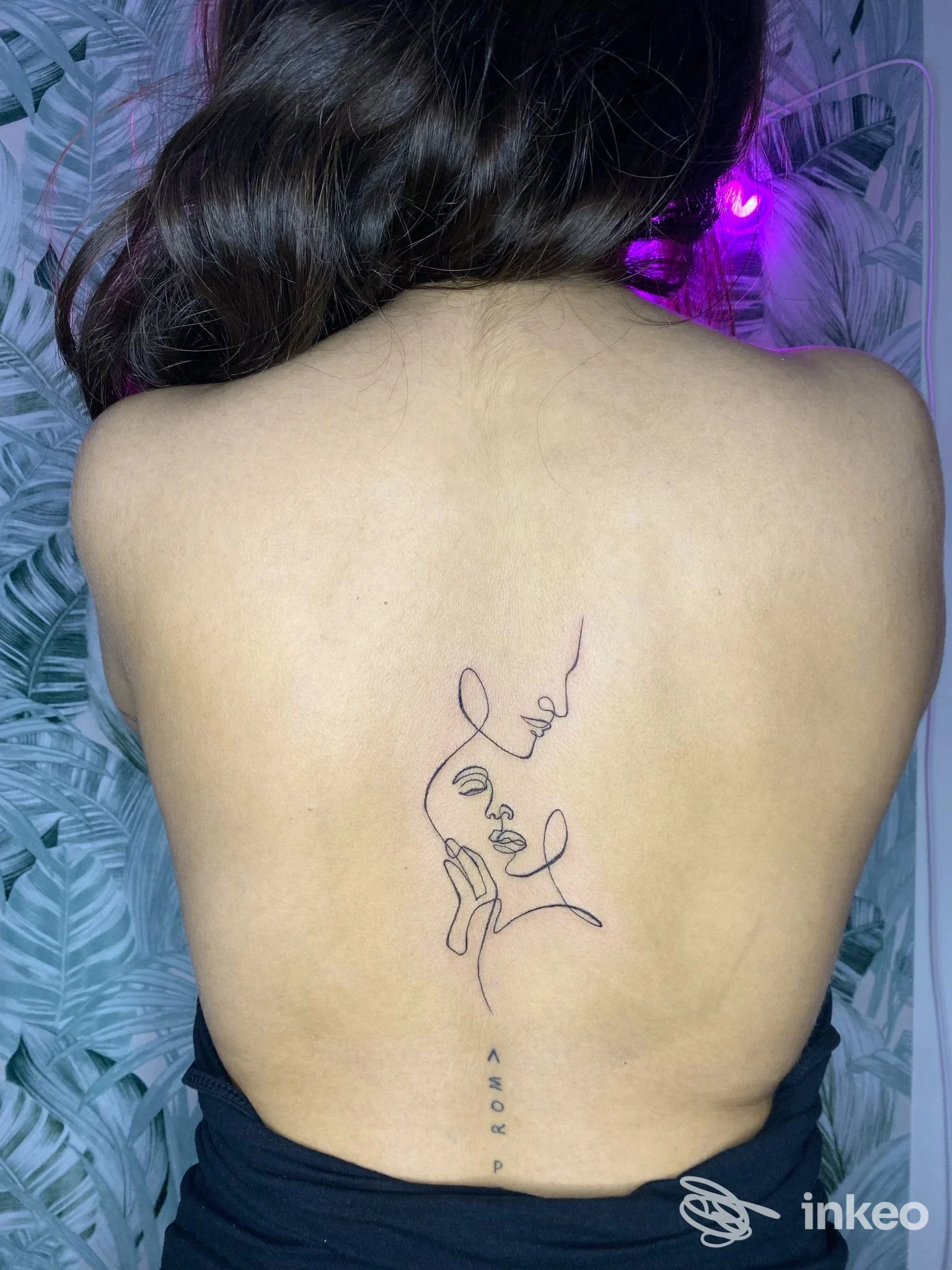 Tatuaggio minimal a linea continua con profilo femminile al centro della schiena, realizzato da WhyNot_Ink a Castel d'Azzano, inquadratura verticale.