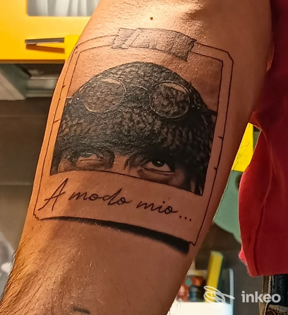 Tatuaggio su avambraccio con ritratto parziale e la scritta "A modo mio...", realizzato da Atramento Studio ad Alessandria.