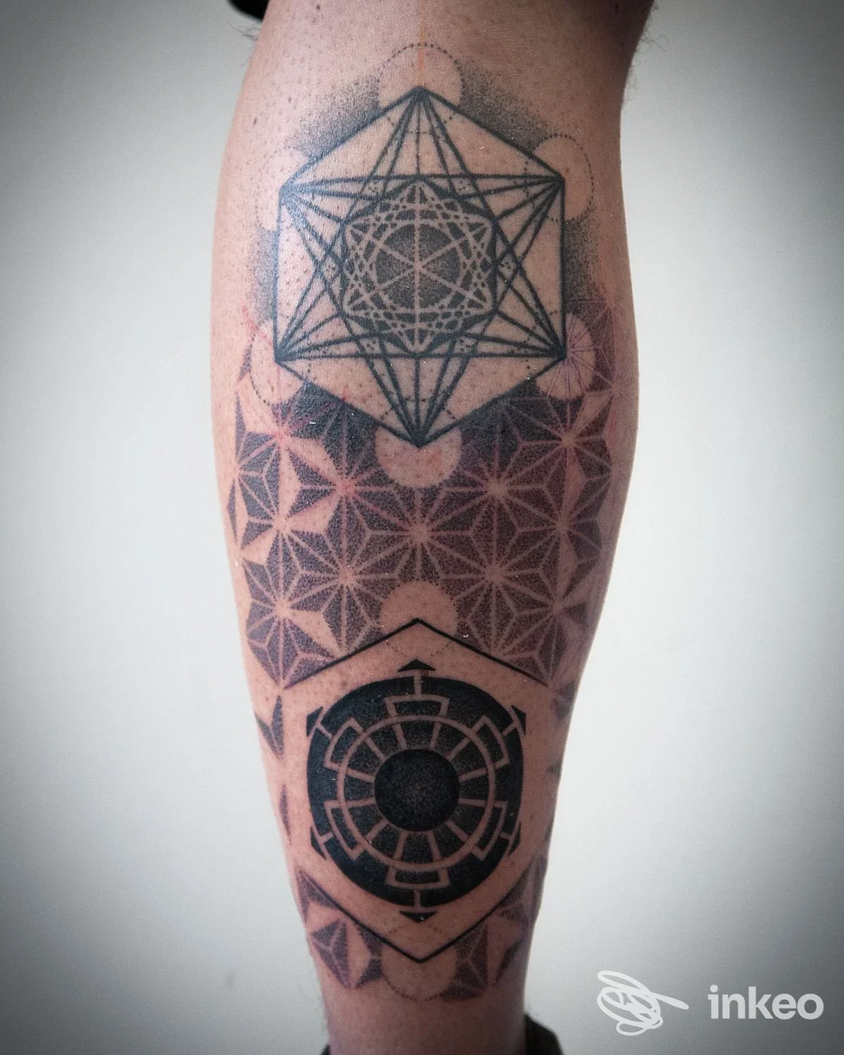 Tattoo geometrico nero su polpaccio realizzato da inkxs atelier a Trento, tre motivi sovrapposti con dettagli puntinati e ombreggiature.