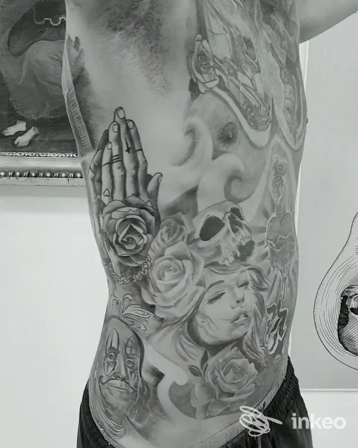 Foto del torso tatuato presso Box Tat2 Studio a Palermo, dettagli black & grey con rose, teschio e volto realistico tatuato.