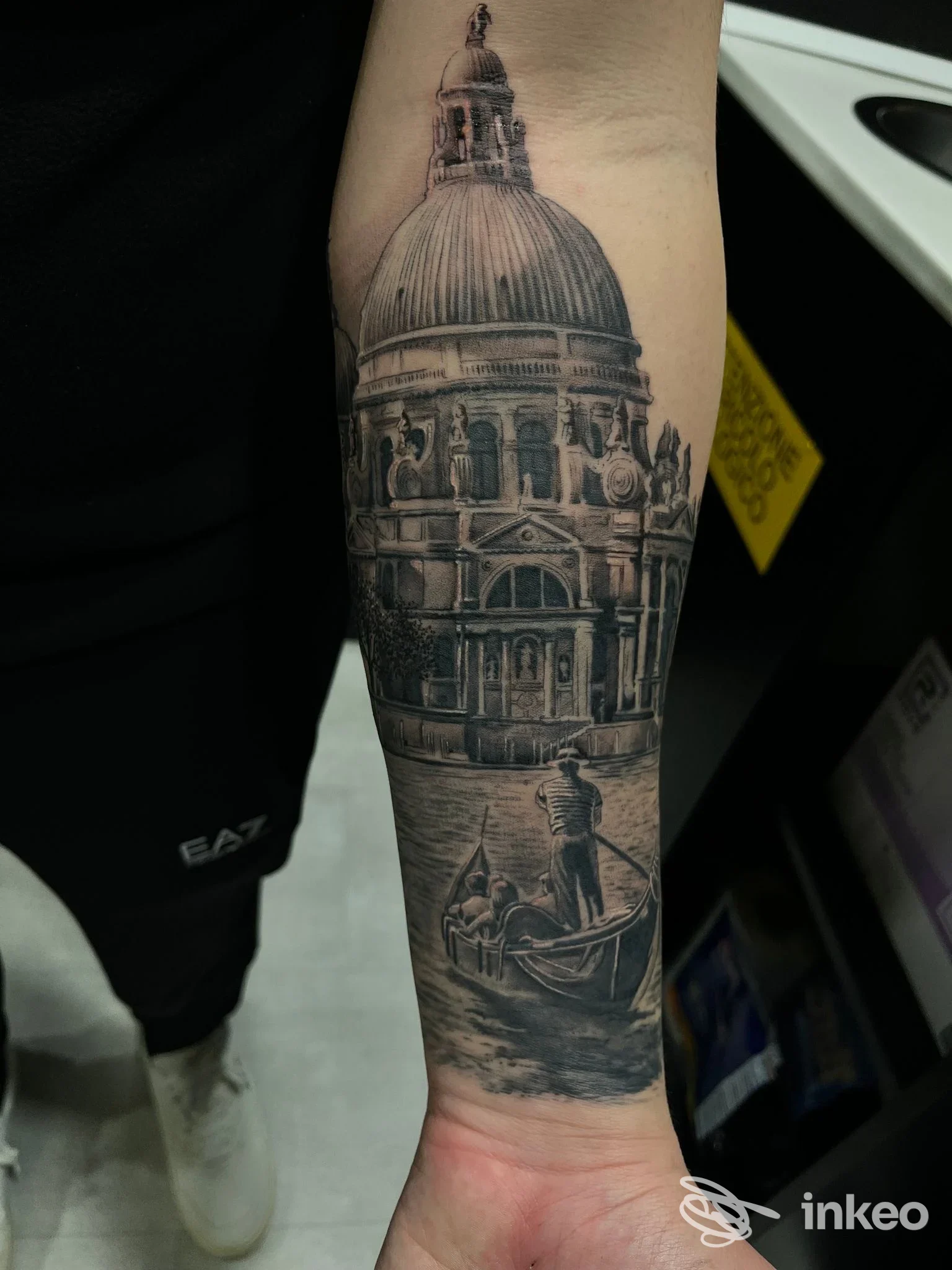 Tatuaggio blackwork in bianco e nero su avambraccio raffigurante la Basilica e una gondola, Black Star, Venezia.