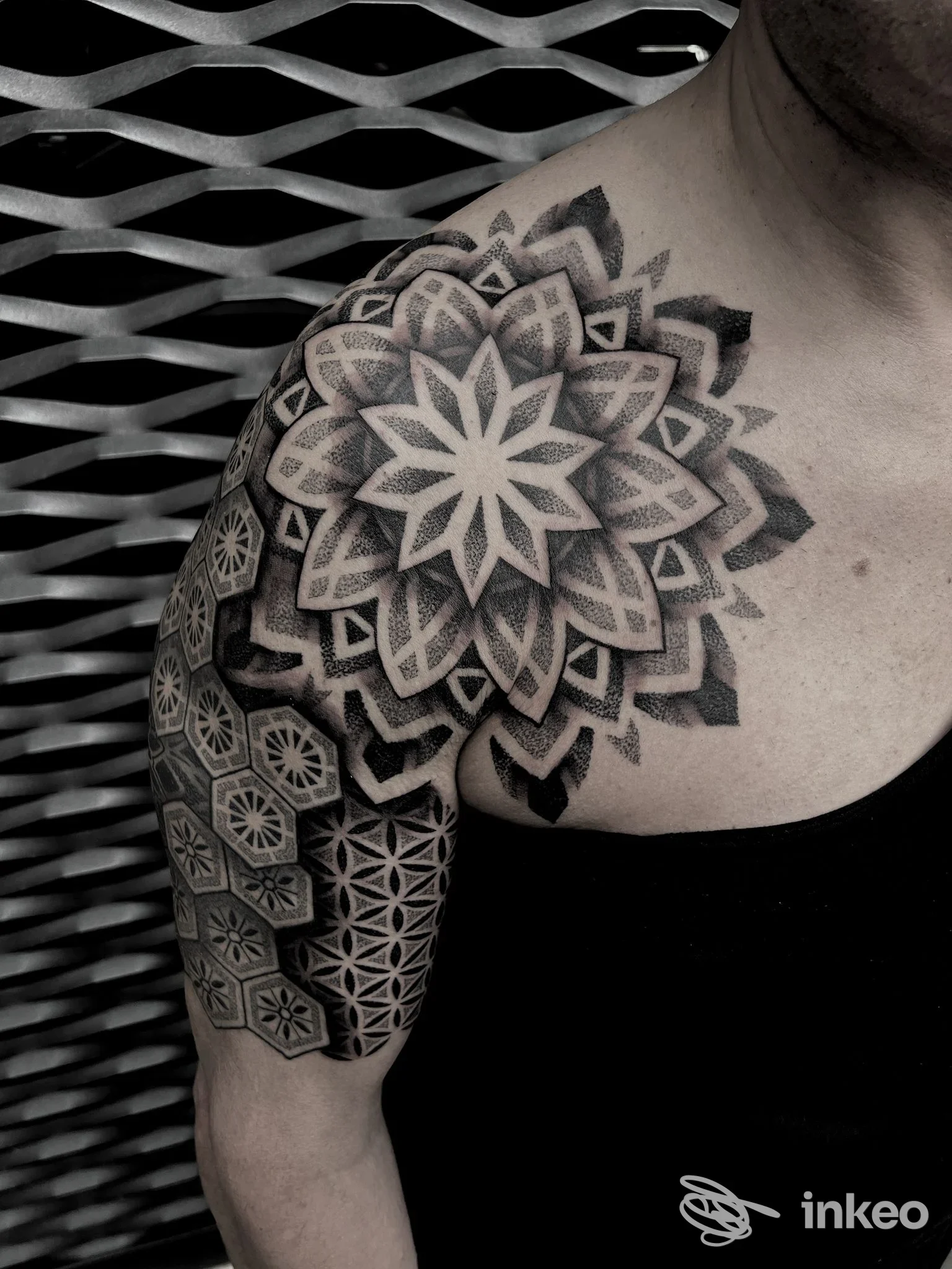 Tatuaggio geometrico a mandala sulla spalla e braccio superiore, foto di Kinda Linda Tattoo, Bologna.