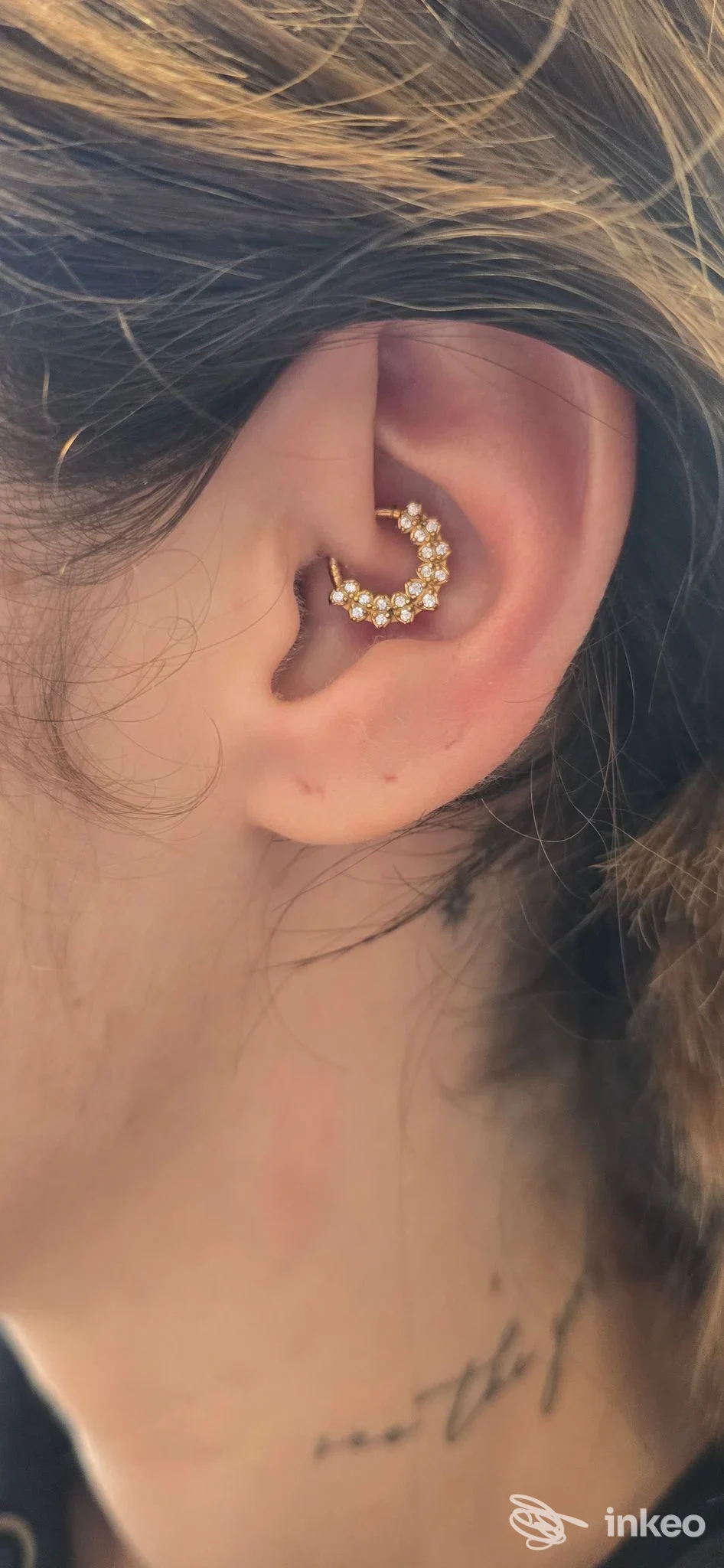 Primo piano di un piercing all'orecchio a mezzaluna con pietre, foto fornita da Inkme Studio Tattoo & Piercing, Monopoli.