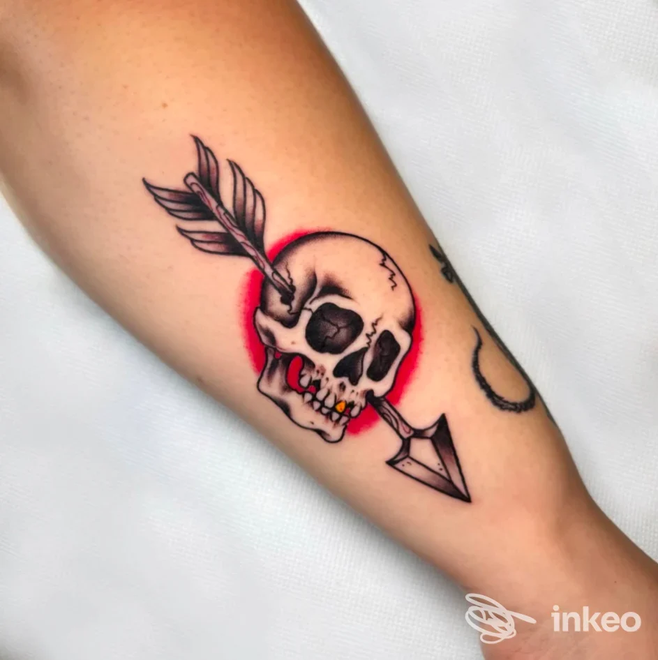 Tatuaggio su avambraccio raffigurante un teschio trafitto da una freccia, realizzato da Fera BodyArtLab a Thiene.