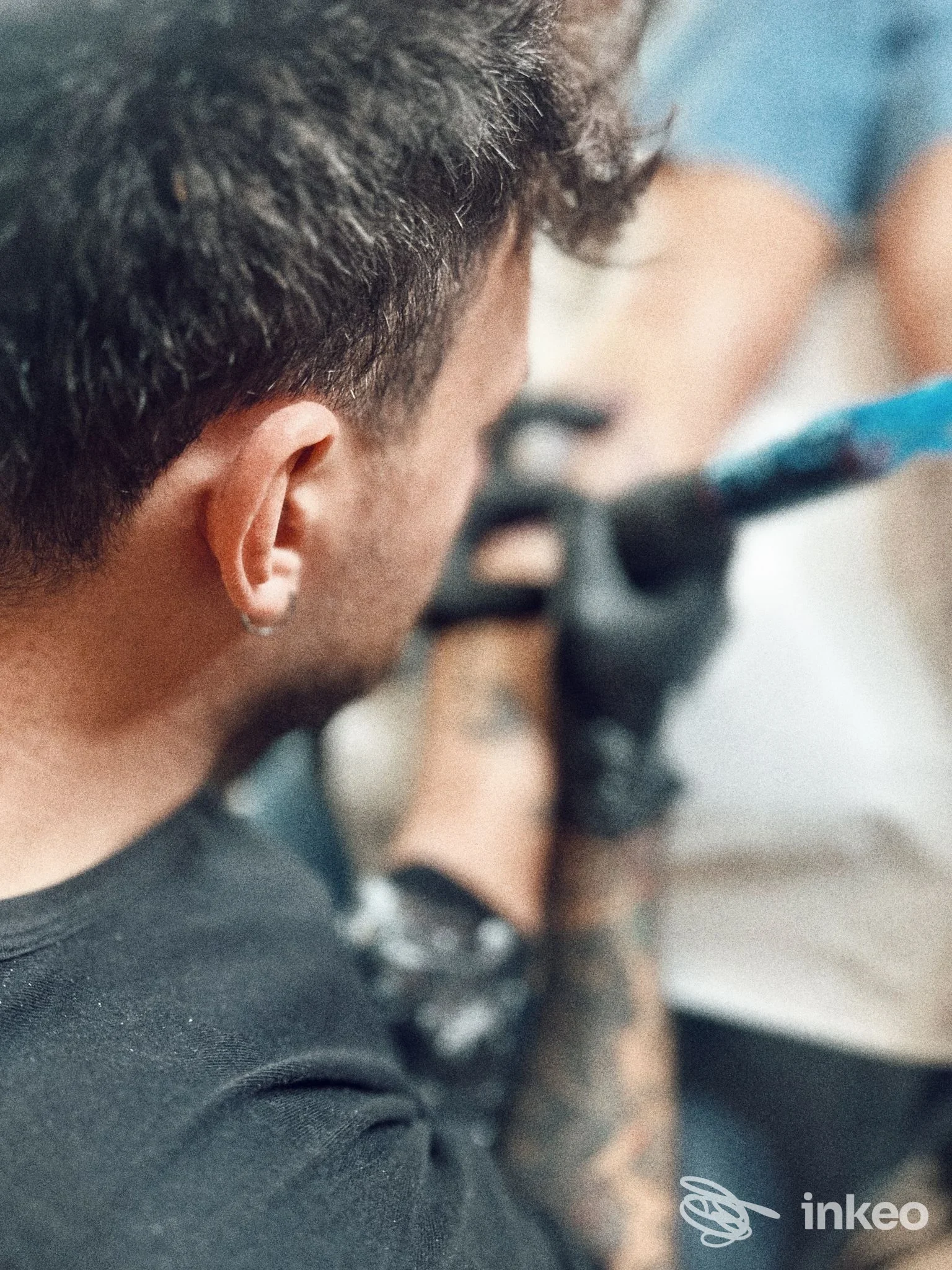 Dettaglio di un tatuatore al lavoro sull'avambraccio di un cliente nello studio Belly Button Tattoo Studio a Calenzano.