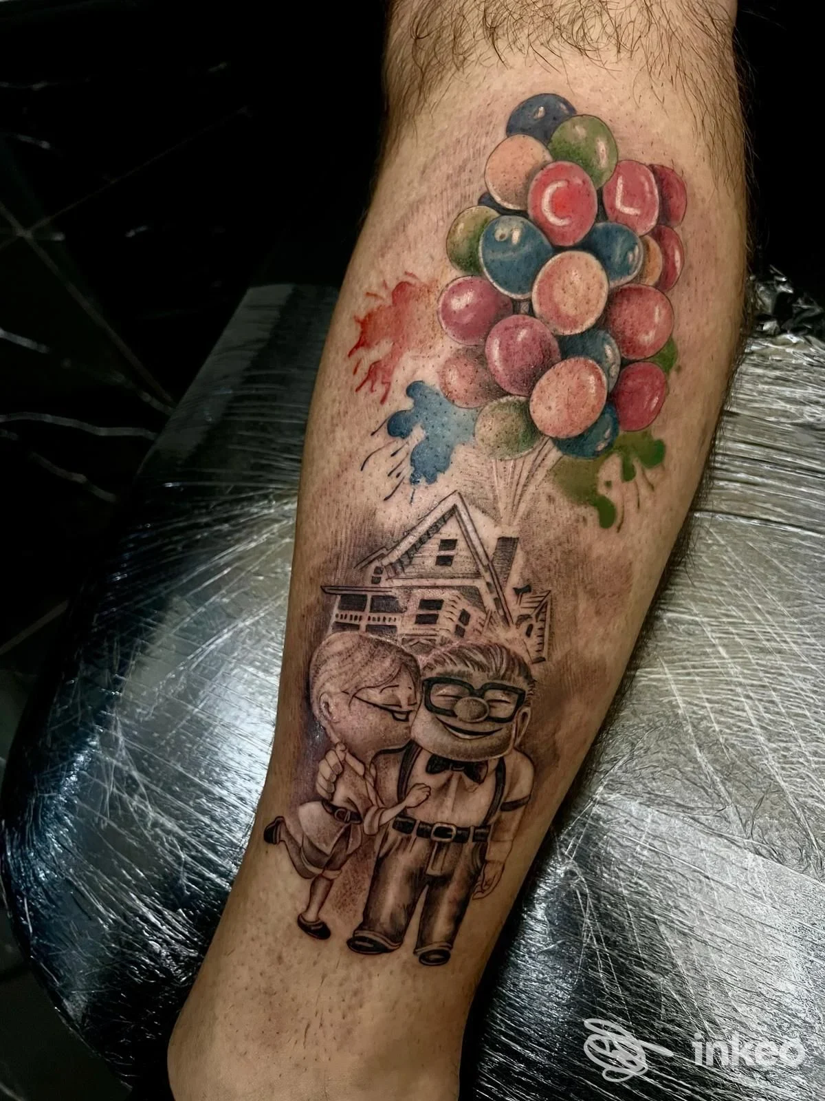 Tatuaggio sul polpaccio con coppia anziana, casa e palloncini colorati — ADRENAL INK, Mesagne.
