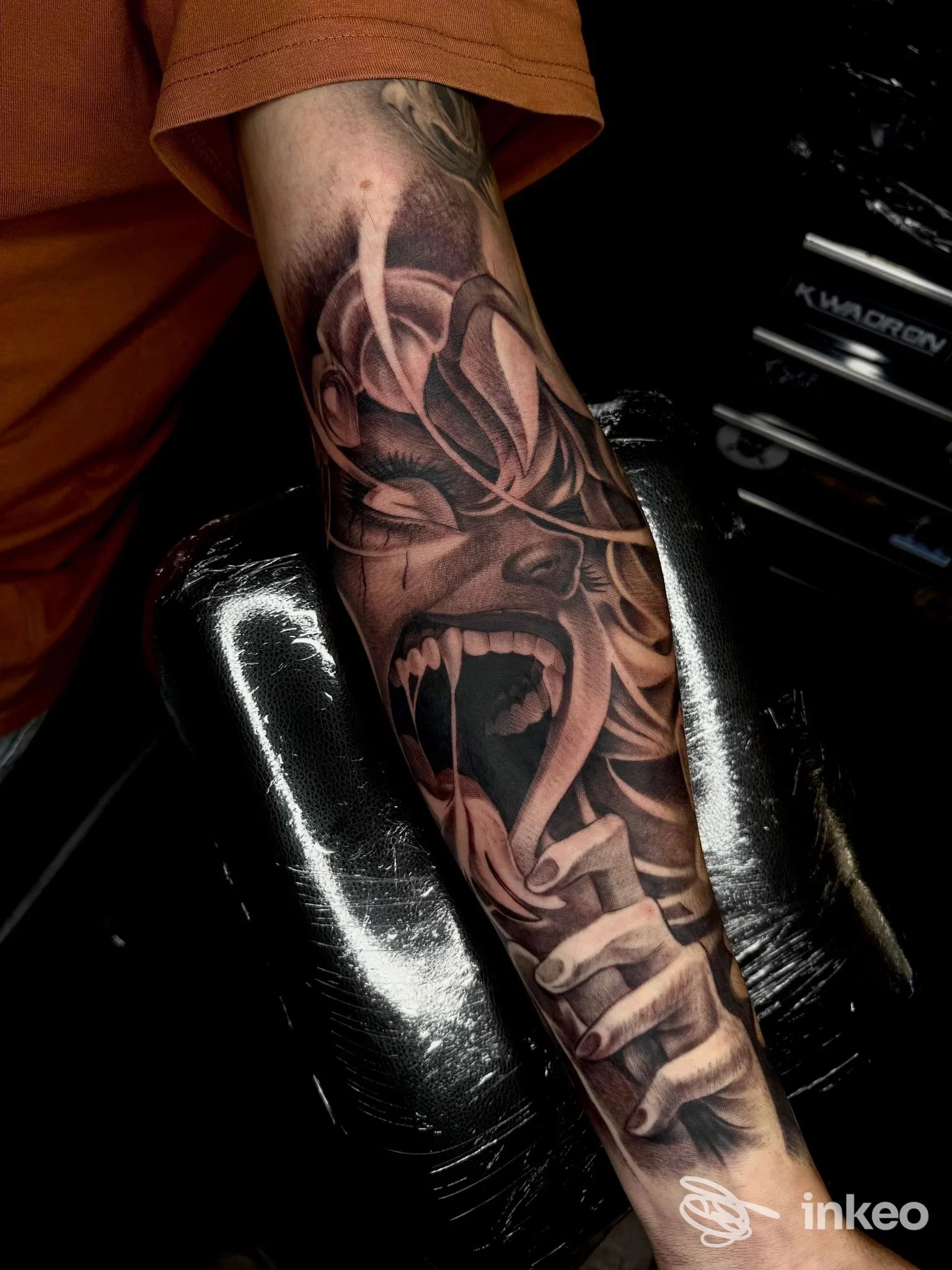 Tatuaggio realistico in bianco e nero su avambraccio con volto urlante e dettagli sfumati, foto per ADRENAL INK, Mesagne.