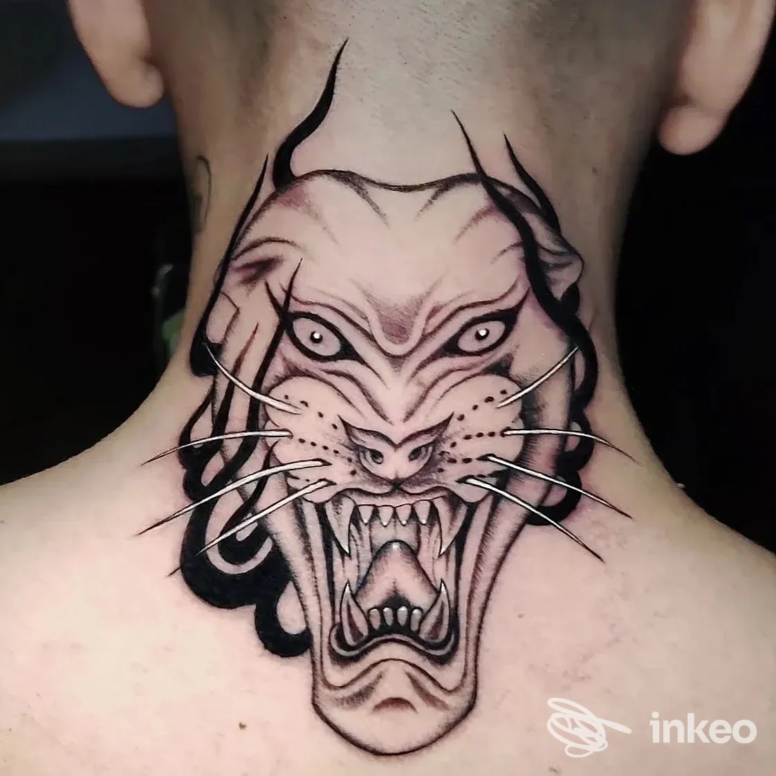 Tatuaggio a figura di testa di felino stilizzata sulla nuca, con linee nere e ombreggiature, realizzato da TEN RIVERS TATTOO a Quarrata.