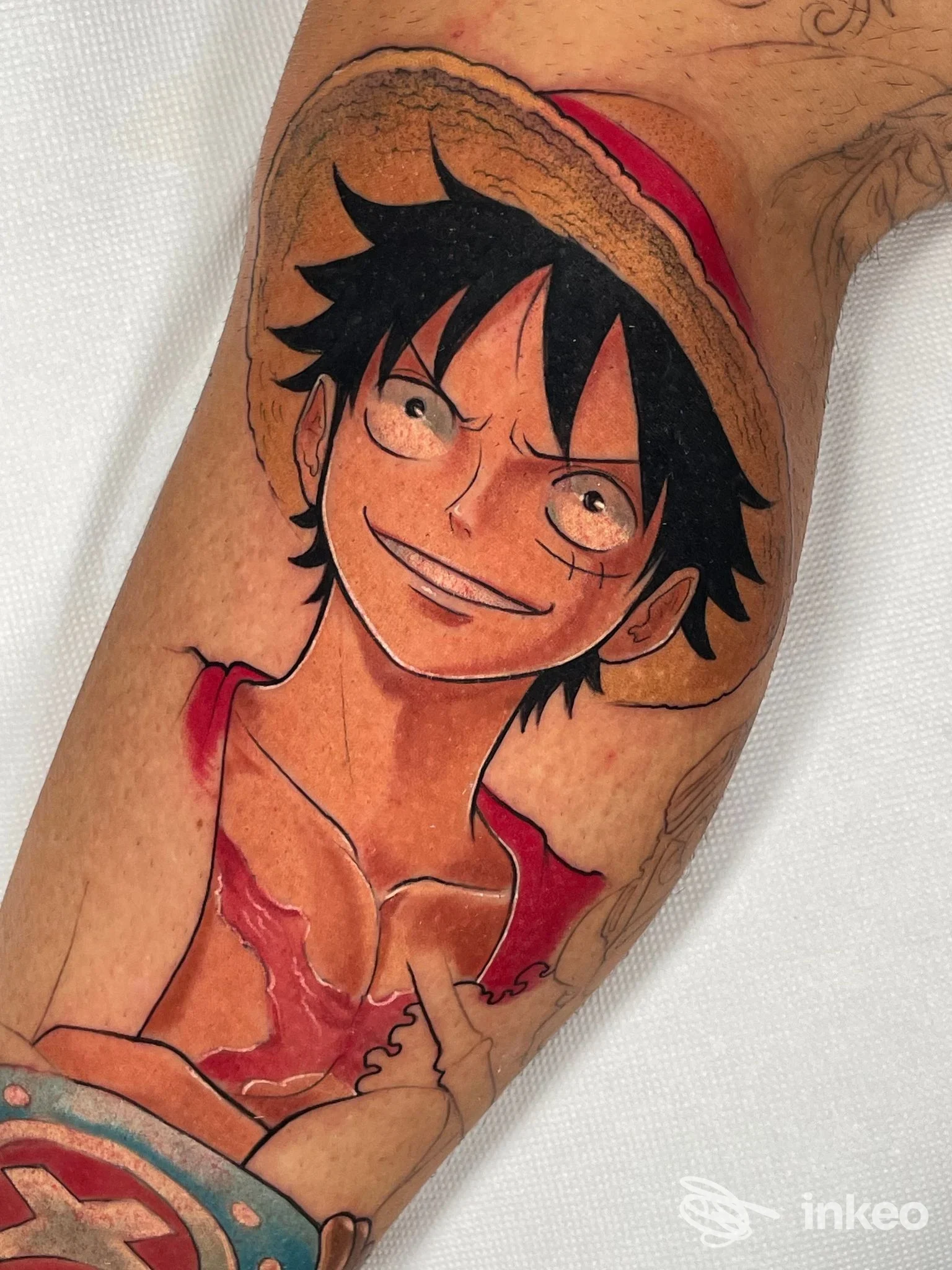 Tatuaggio a colori in stile anime raffigurante Monkey D. Luffy sul polpaccio, realizzato da Hermesink a Genova.