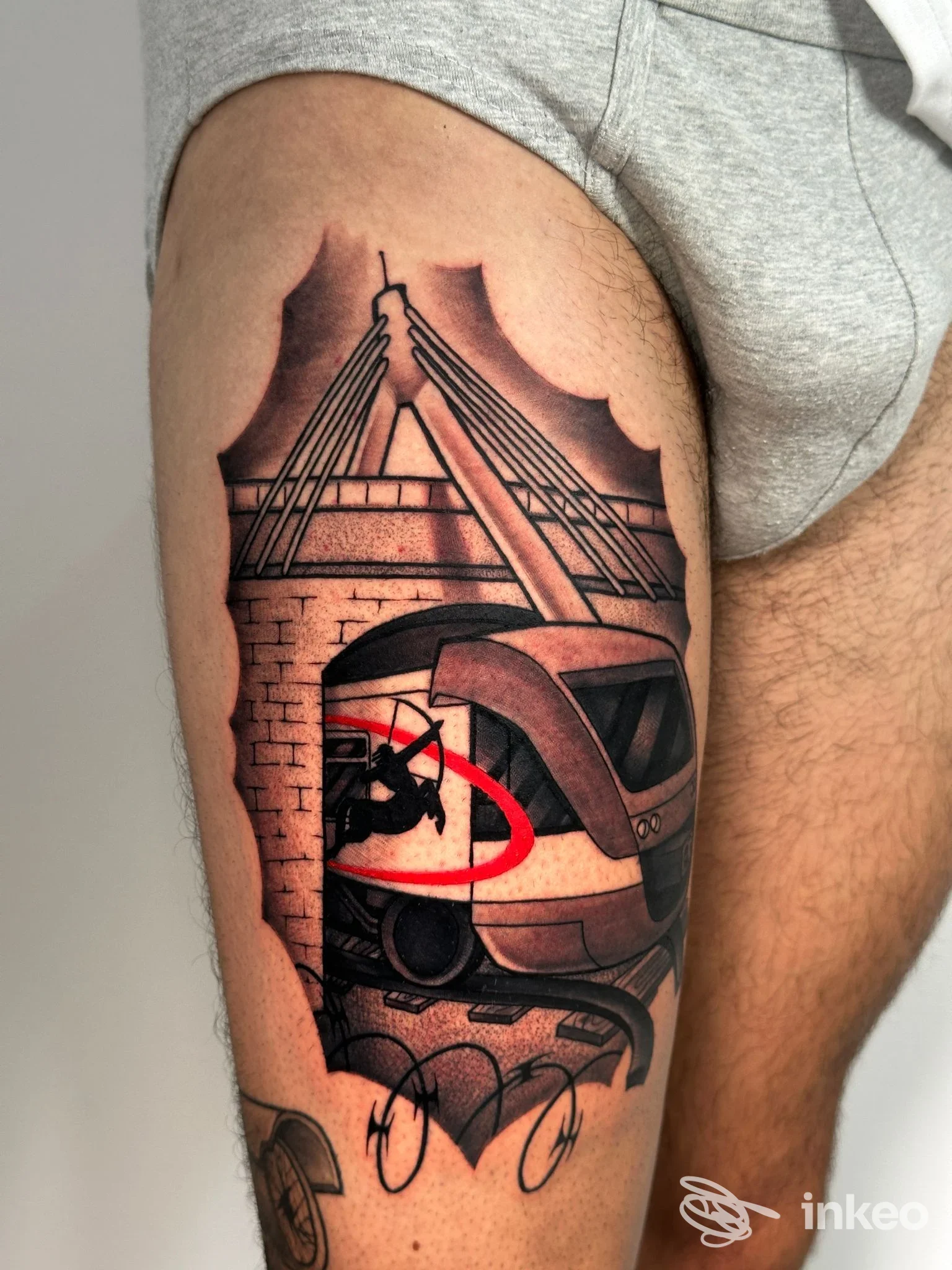 Tatuaggio su coscia raffigurante un treno e un ponte, realizzato da Outline Bari, Bari.