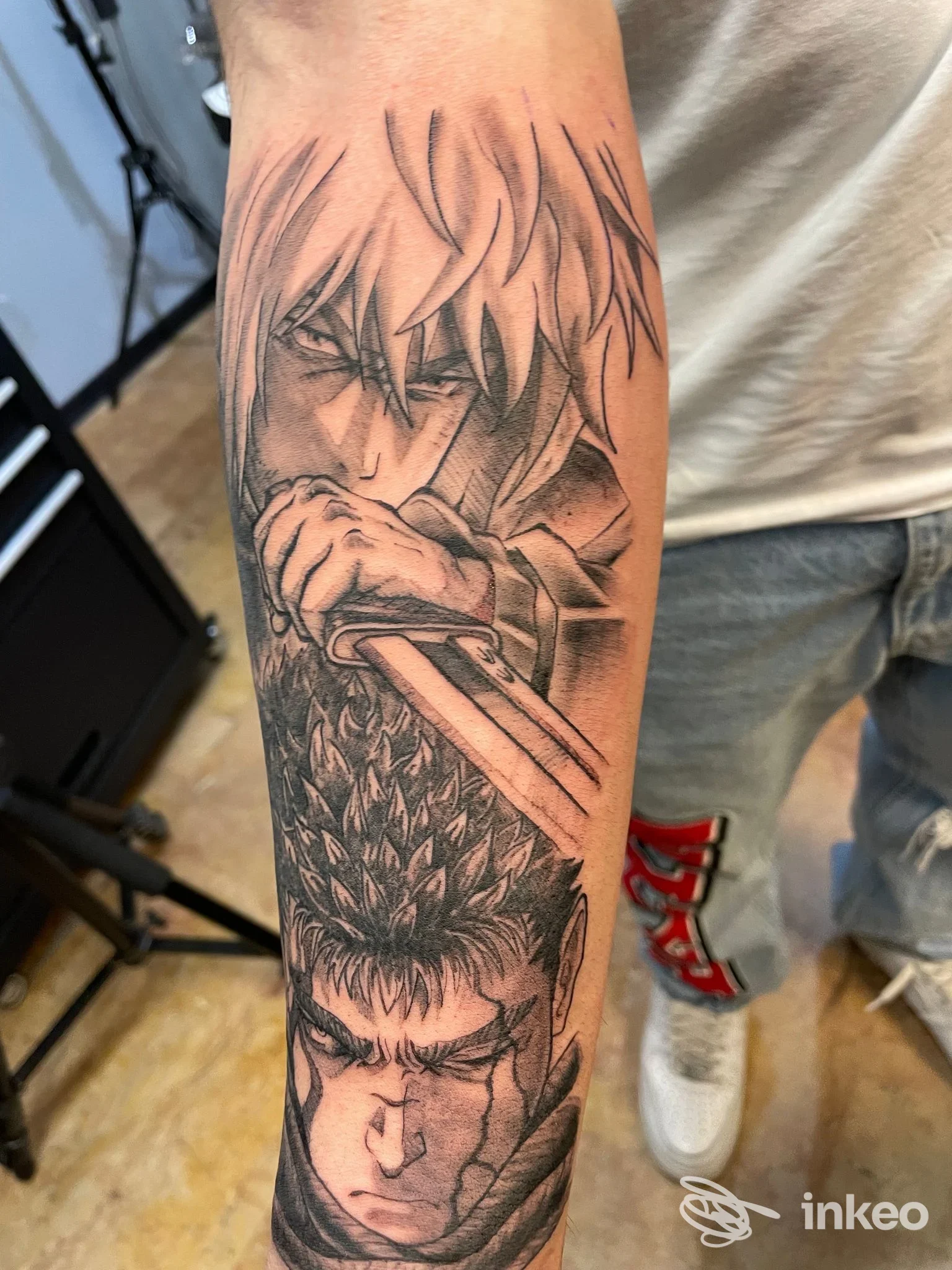 Tatuaggio black & grey su avambraccio con volti in stile anime, scattato presso Black Water Tattoo Parlour a Verona.