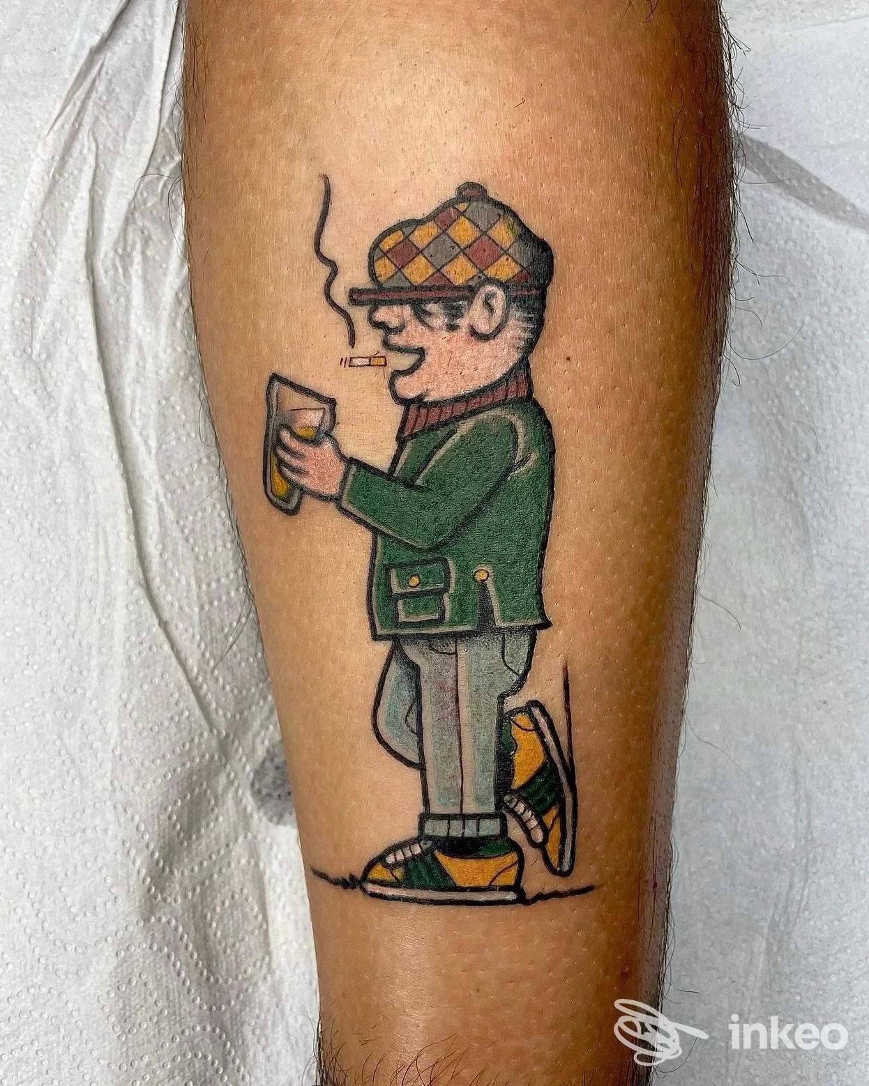 Tatuaggio su polpaccio raffigurante un uomo fumante con berretto e boccale di birra, realizzato da Super Faust Tattoo, Verona.