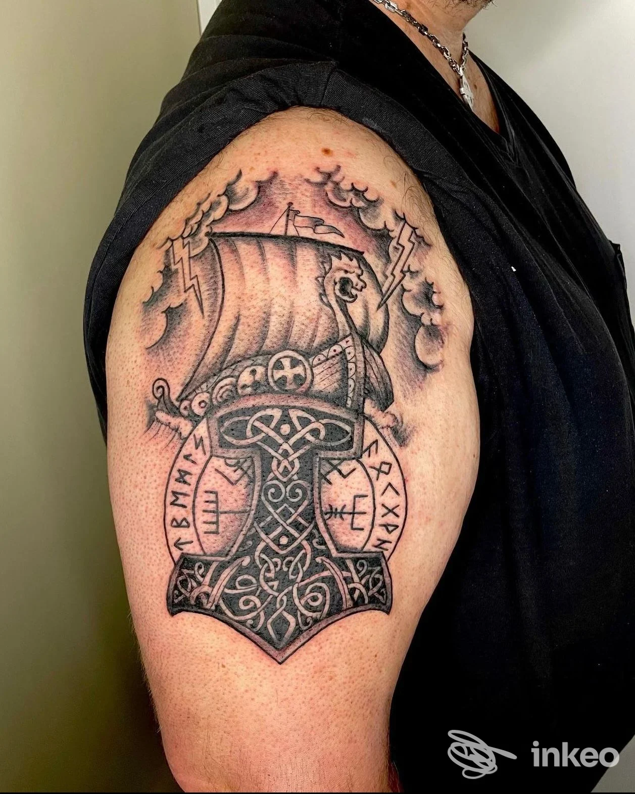 Grande tatuaggio norreno sul bicipite destro realizzato da Super Faust Tattoo a Verona: martello intrecciato e nave vichinga.