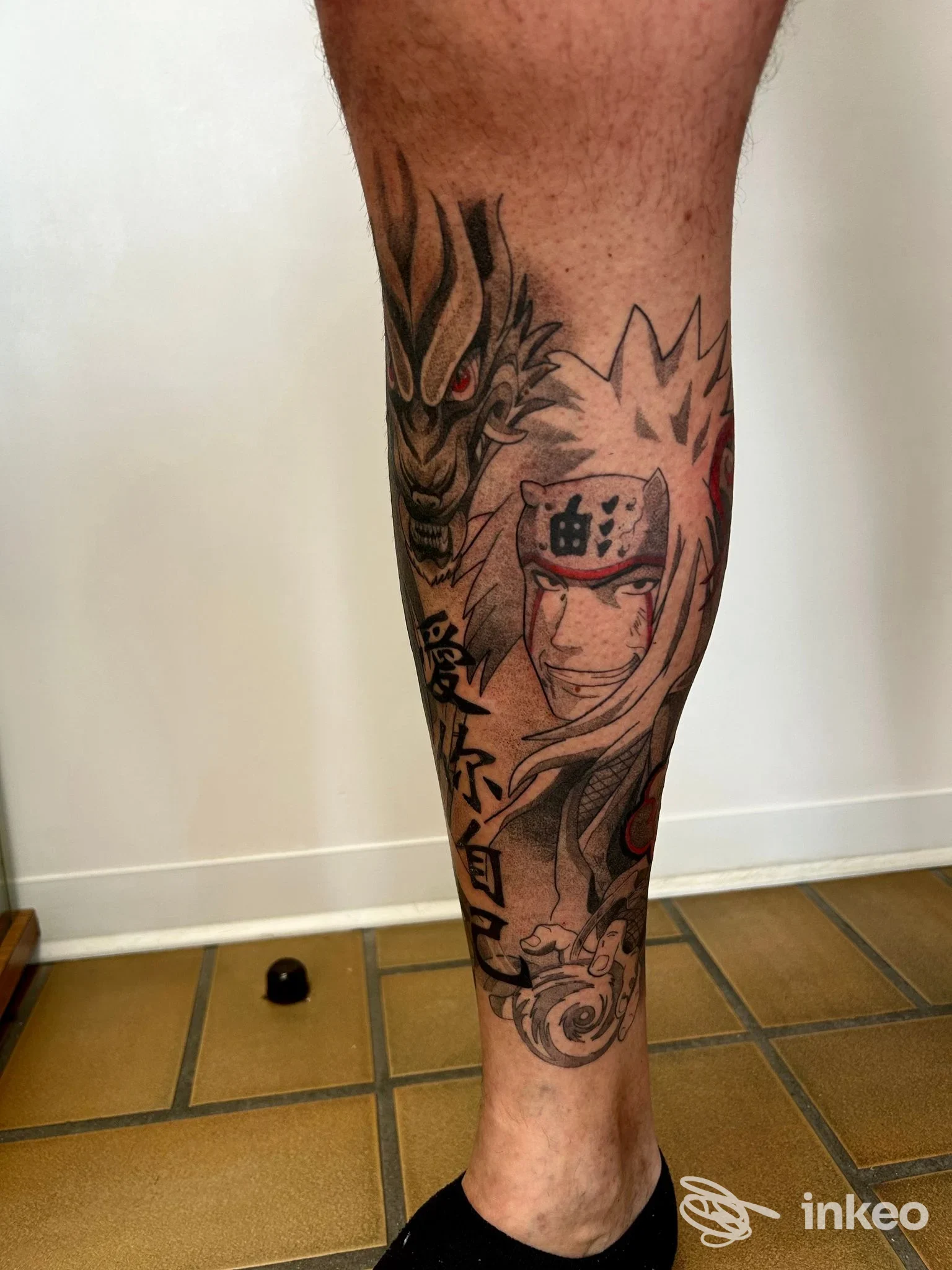 Tatuaggio a colori sul polpaccio con volto in stile anime, dragone e caratteri giapponesi — Studio Tattoo INK-IOSTRO TATTOO, Bosaro.
