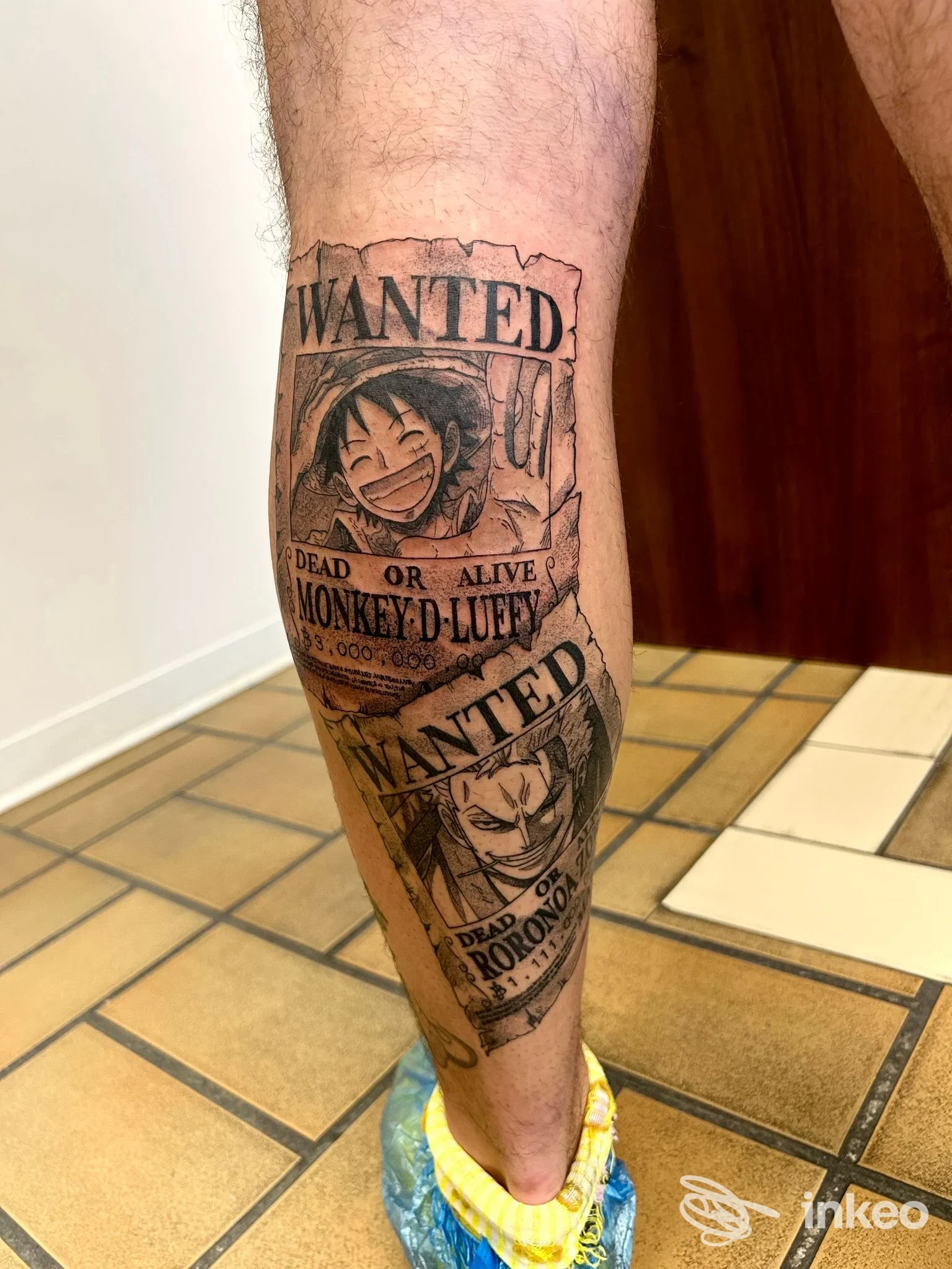 Polpaccio con due tatuaggi stile poster 'WANTED' fotografati presso Studio Tattoo INK-IOSTRO TATTOO, Bosaro.