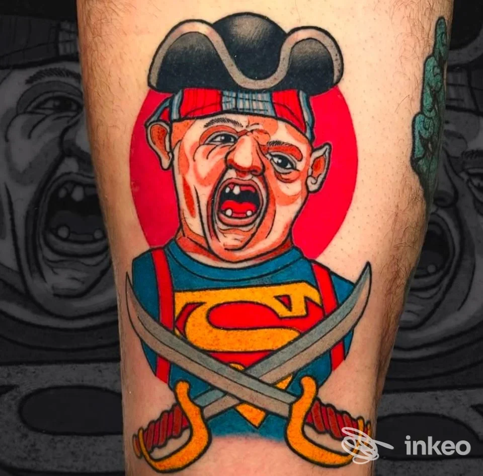 Tatuaggio colorato su polpaccio raffigurante figura caricaturale da pirata con sfondo rosso. Aseptic Studio, Trento.