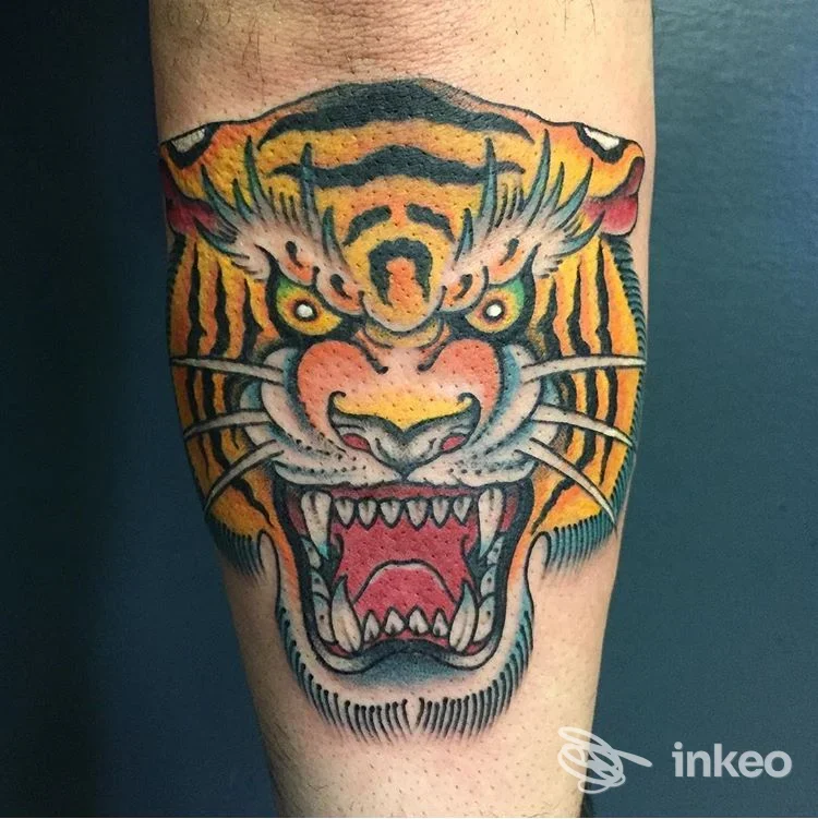 Tatuaggio tradizionale di testa di tigre sull'avambraccio, fotografato da vicino; opera mostrata da Aseptic Studio, Trento.