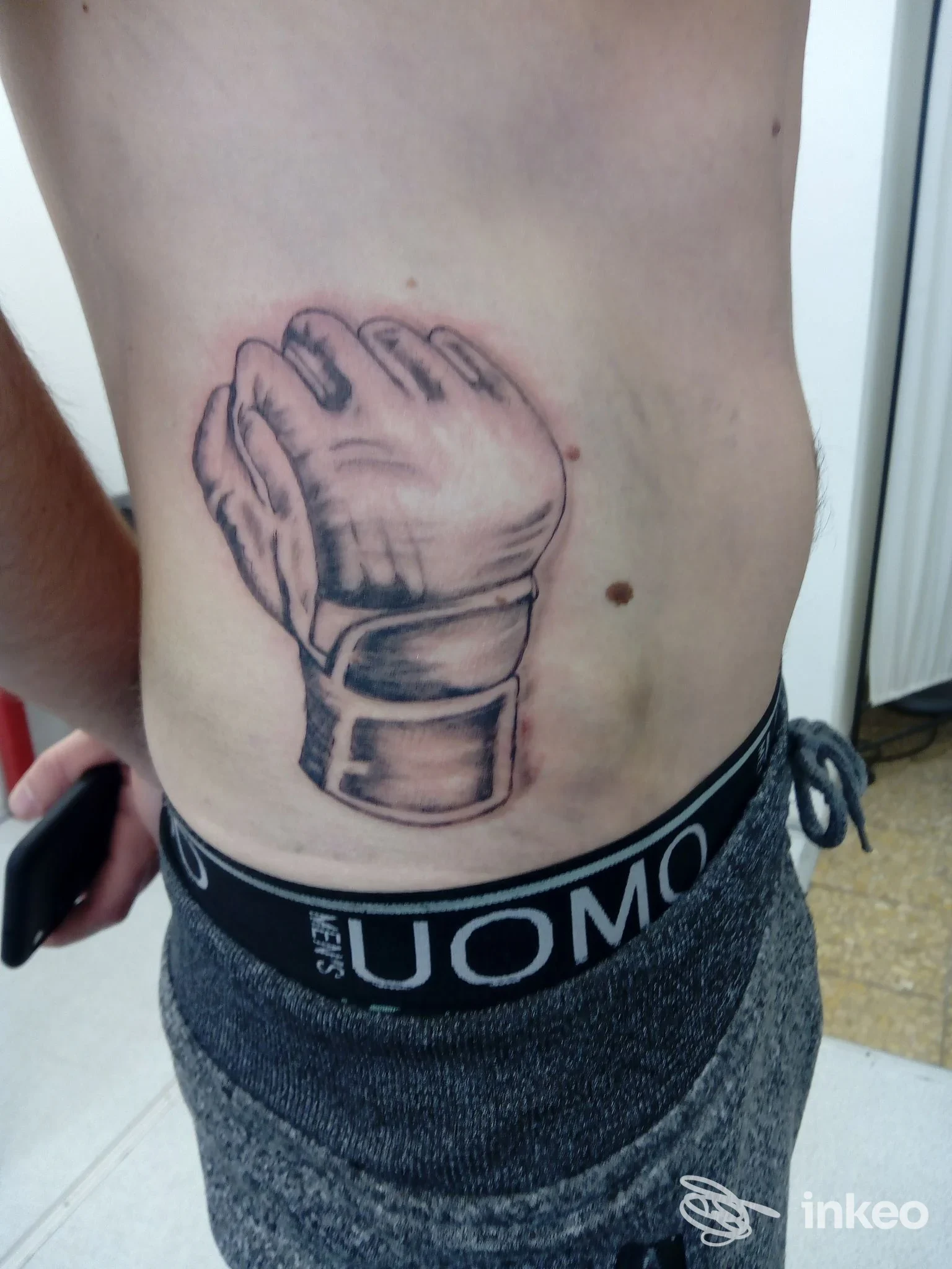 Tatuaggio di un guanto sul fianco realizzato da Hobby Tattoo Art Studio Di Galardi Paolo a Pistoia.