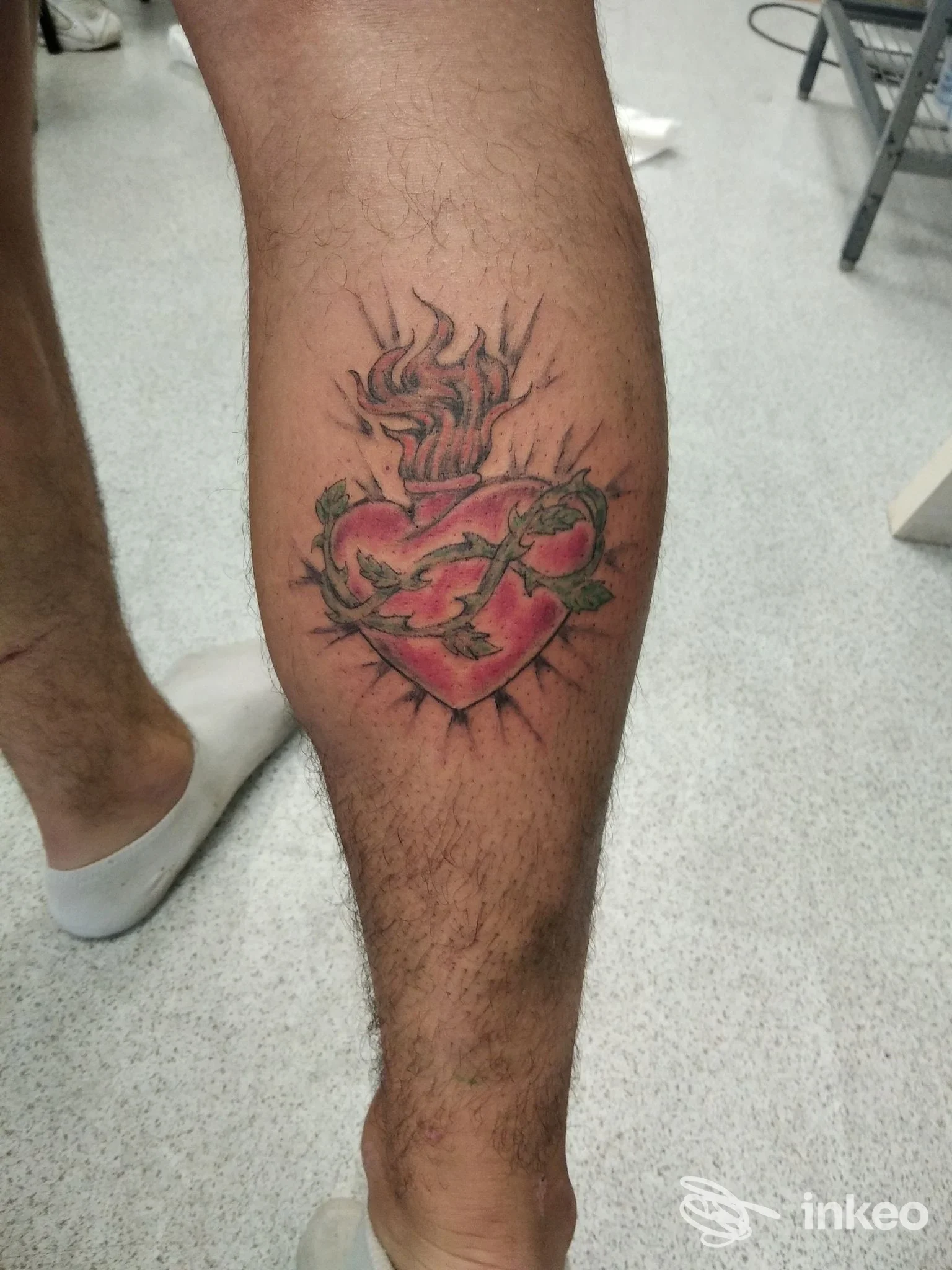 Tatuaggio a cuore fiammeggiante avvolto da spine sul polpaccio, scattato nello studio Hobby Tattoo Art Studio a Pistoia.