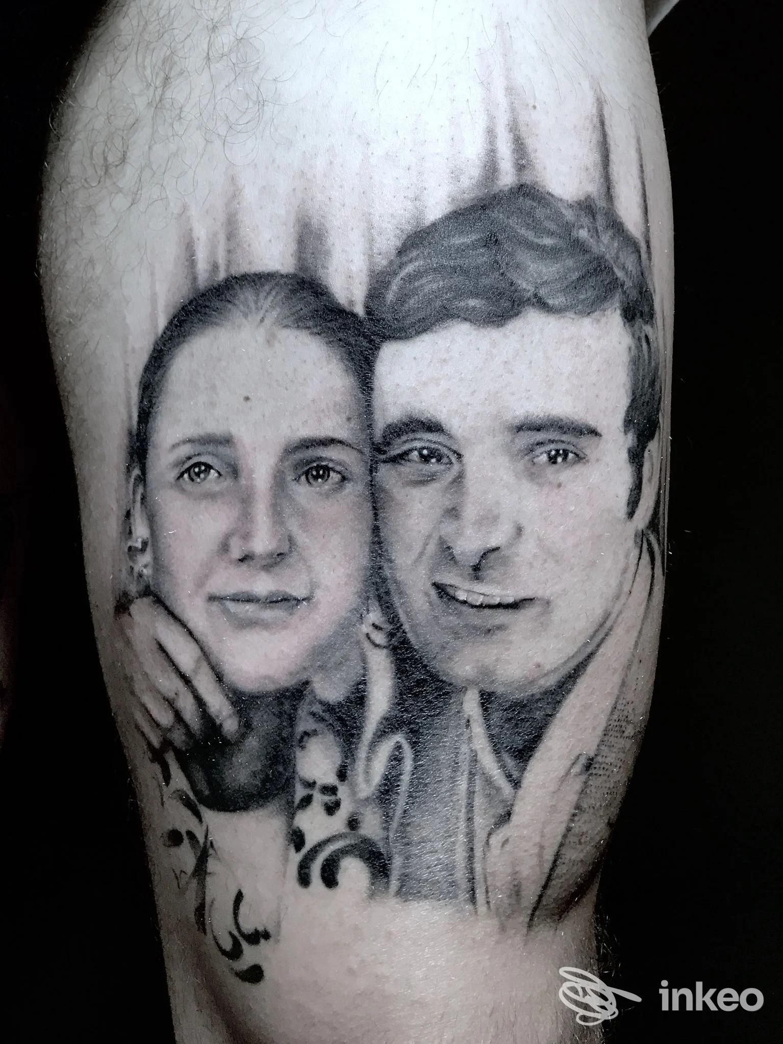 Tatuaggio realistico in bianco e nero: ritratto di due volti inchiostrati sul polpaccio. CAONTATTOO STUDIO, Viterbo.