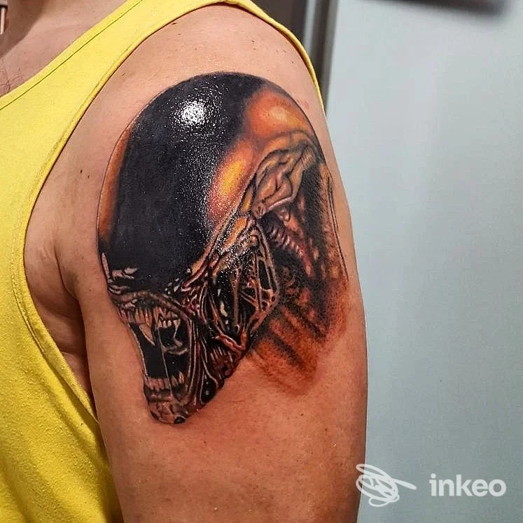 Tatuaggio realistico di testa aliena sul braccio superiore di un cliente, foto inviata da CAONTATTOO STUDIO, Viterbo.