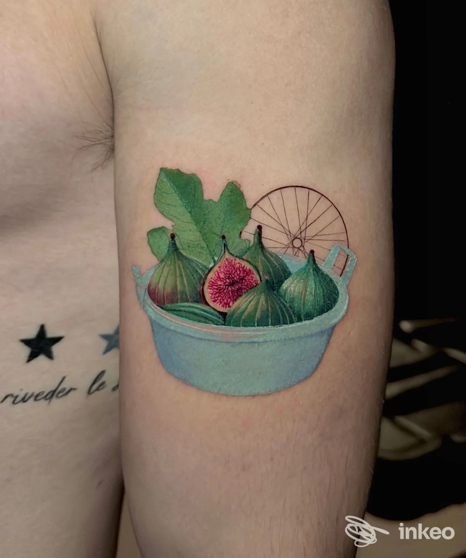 Tatuaggio a colori raffigurante fichi in una ciotola sul braccio superiore, Vito Falco Tattoo Studio, Bari