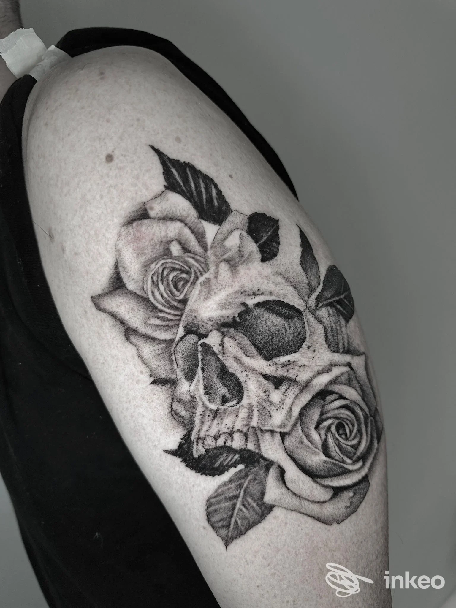 Tatuaggio nero e grigio di teschio e rose sull'omero, realizzato da LOCUSWOMB tattoo space a Barberino di Mugello.