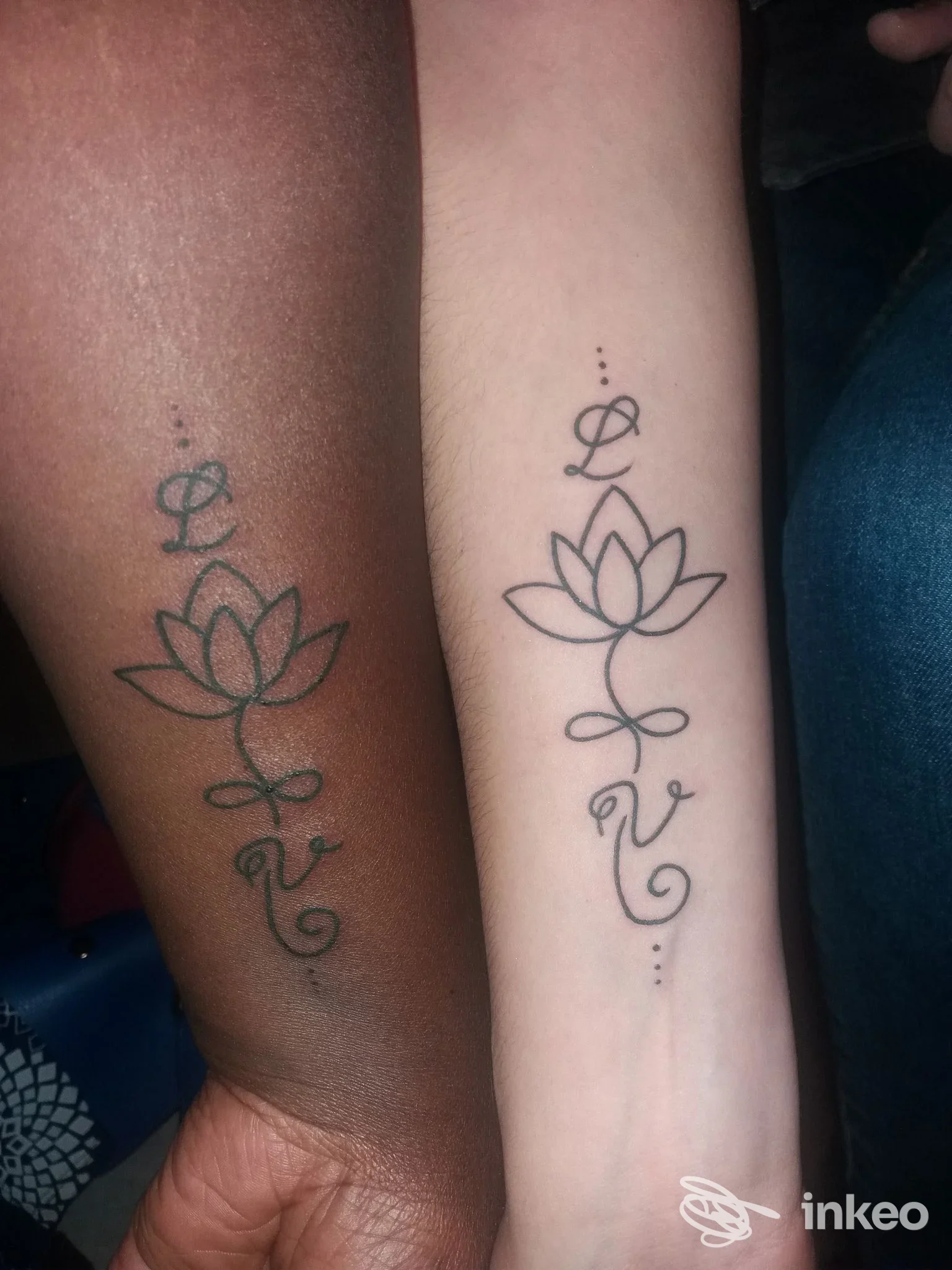 Due avambracci con tatuaggi identici a loto e iniziali, foto fornita dallo studio Tattoo Rudy a Meina.