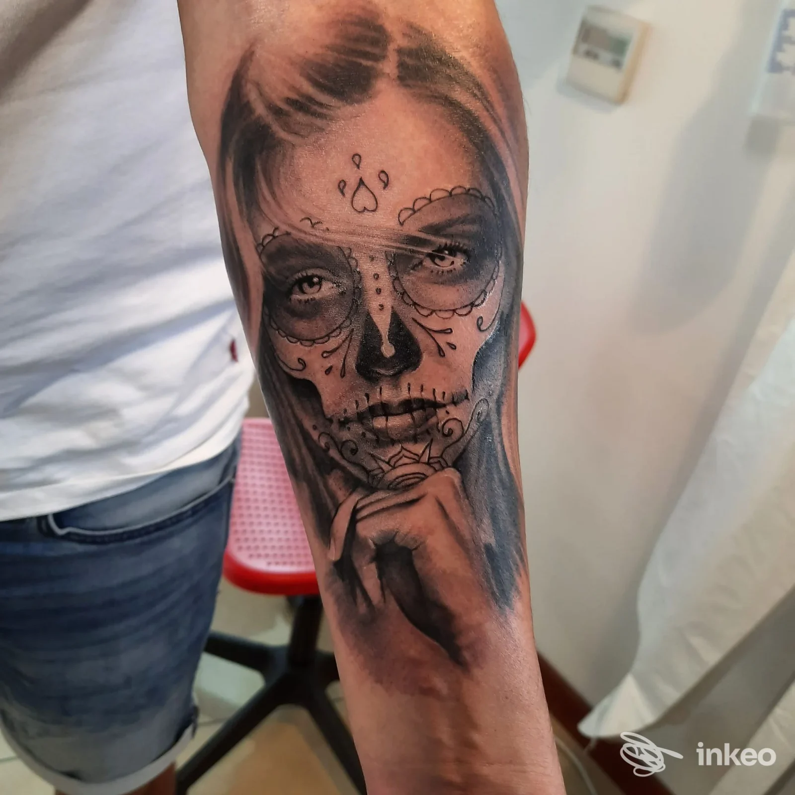 Tatuaggio in bianco e nero sul pavambraccio raffigurante un volto sugar skull realizzato da La Malafede Tattoo, Conegliano.