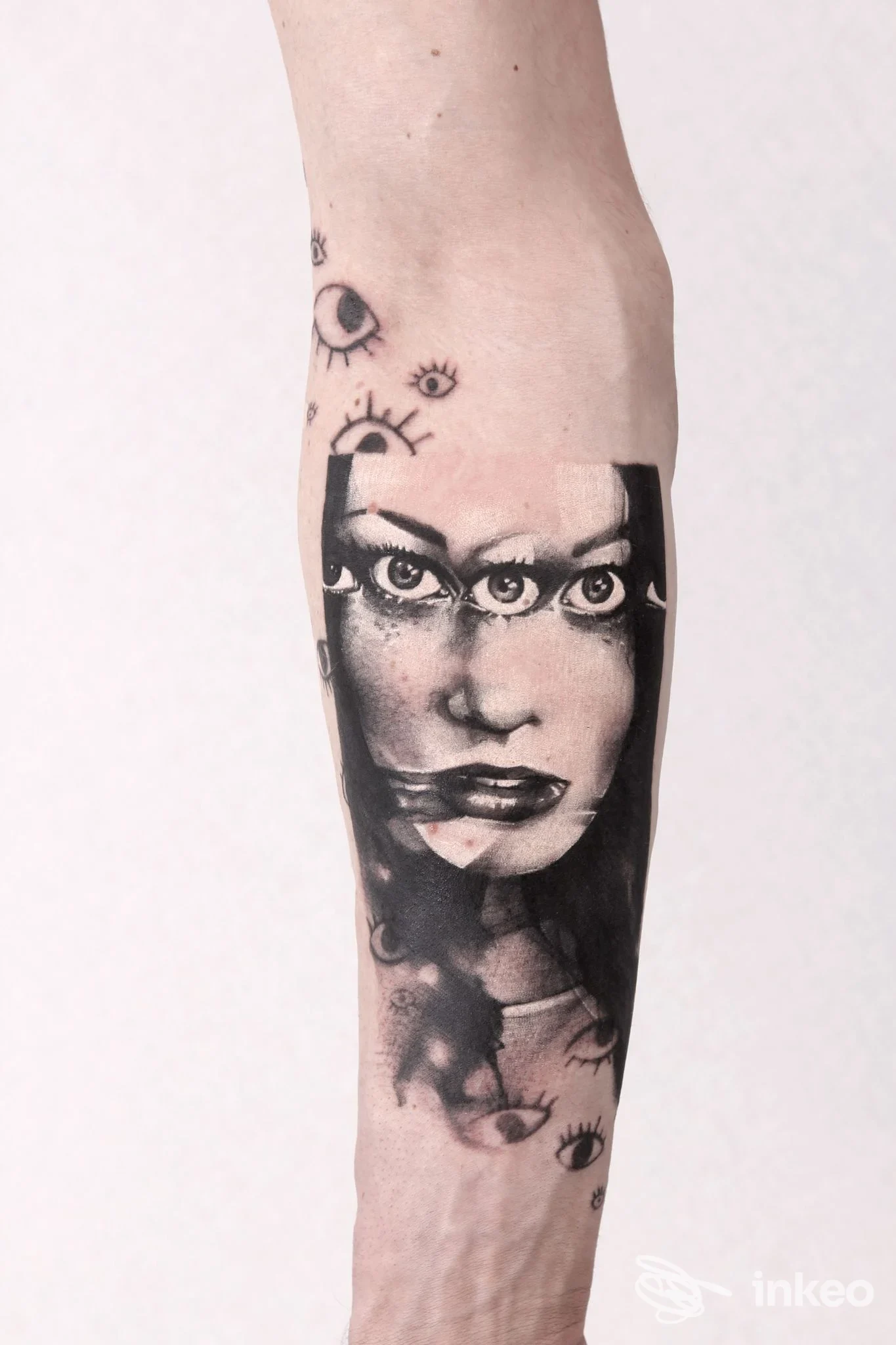 Tatuaggio realistico in bianco e nero su avambraccio: volto femminile frammentato con occhi sovrapposti. La Malafede Tattoo, Conegliano.
