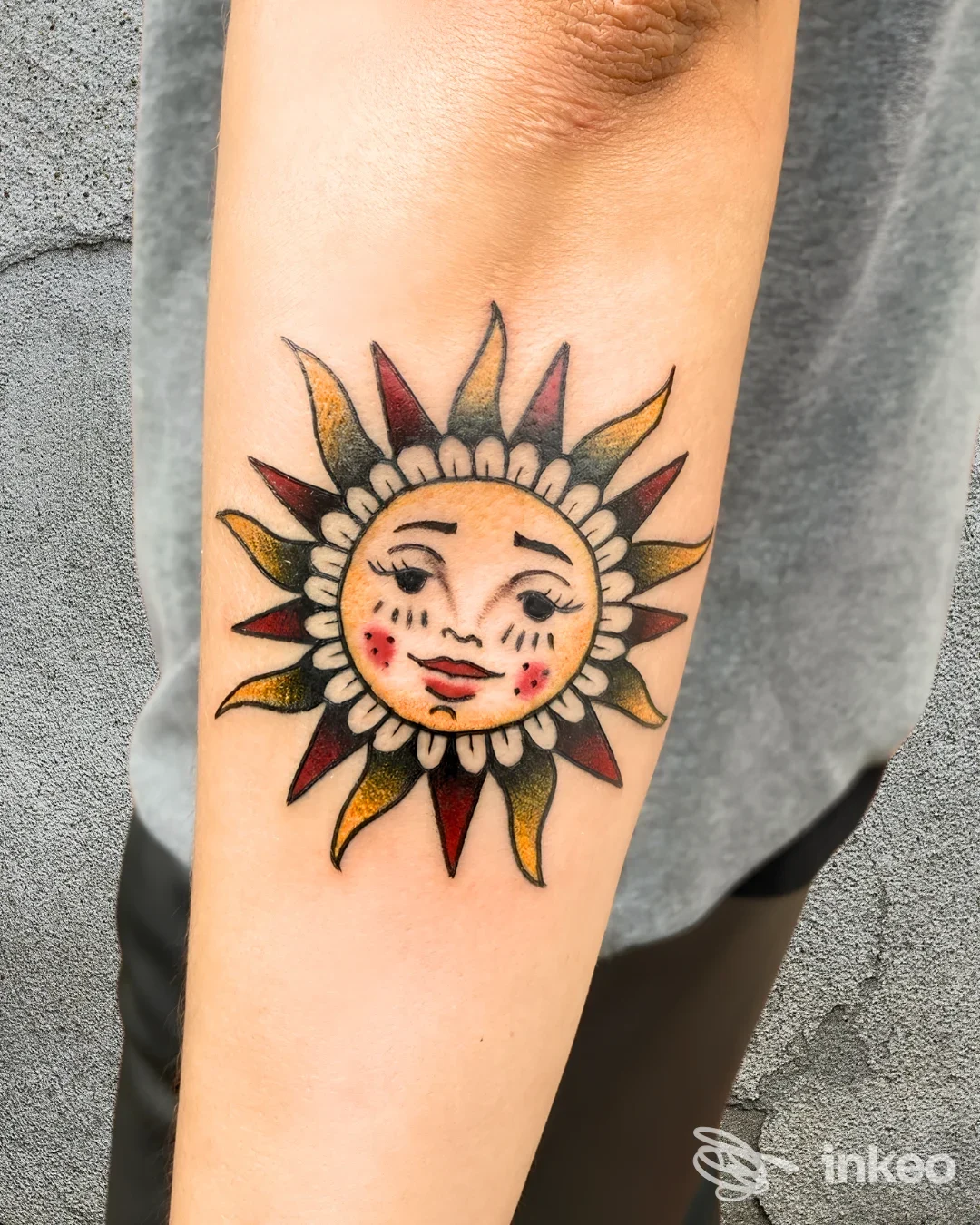 Tatuaggio a forma di sole con volto sull'avambraccio, fotografia di Good Inside Tattoo, Latina.