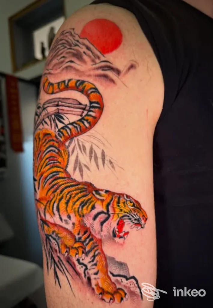 Tatuaggio su spalla e braccio superiore con tigre colorata, montagne e sole rosso. Ladies & Gentlemen Vicenza, Vicenza.