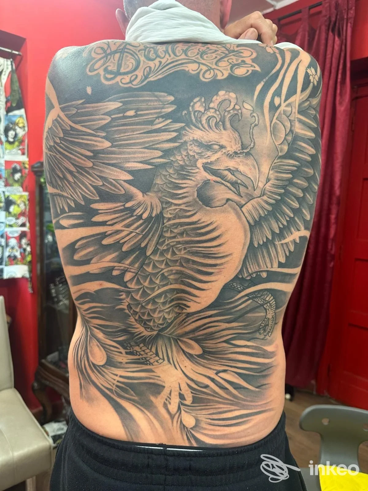Grande tatuaggio a inchiostro nero e grigio a forma di fenice che copre l'intera schiena, realizzato da Art Studio Tattoo Di Panta Daniele a Civita Castellana.