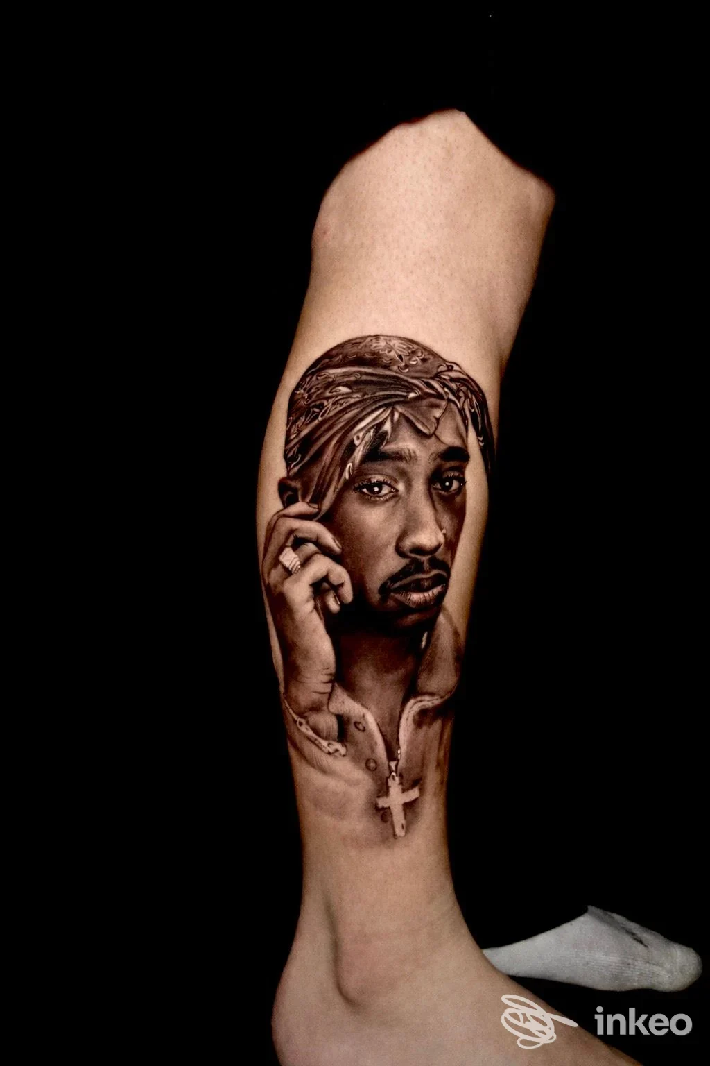Ritratto iperrealista tatuato sul polpaccio con forti sfumature in bianco e nero, opera di Ink Project 29 a Palo del Colle.