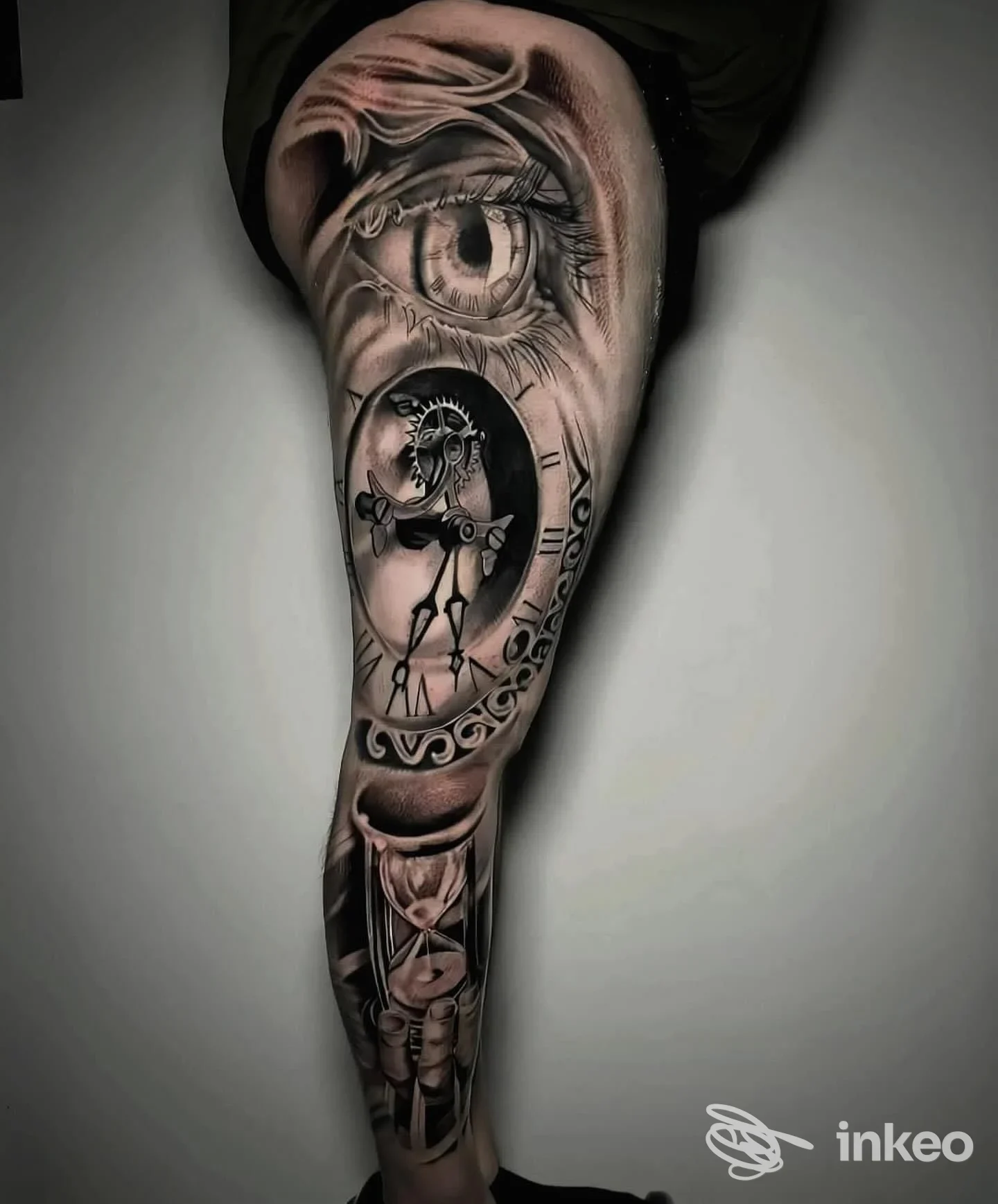 Manica tatuata realistca su gamba con occhio, ingranaggi e clessidra — foto condivisa dallo studio Indelebile Studio Tattoo a Sava.