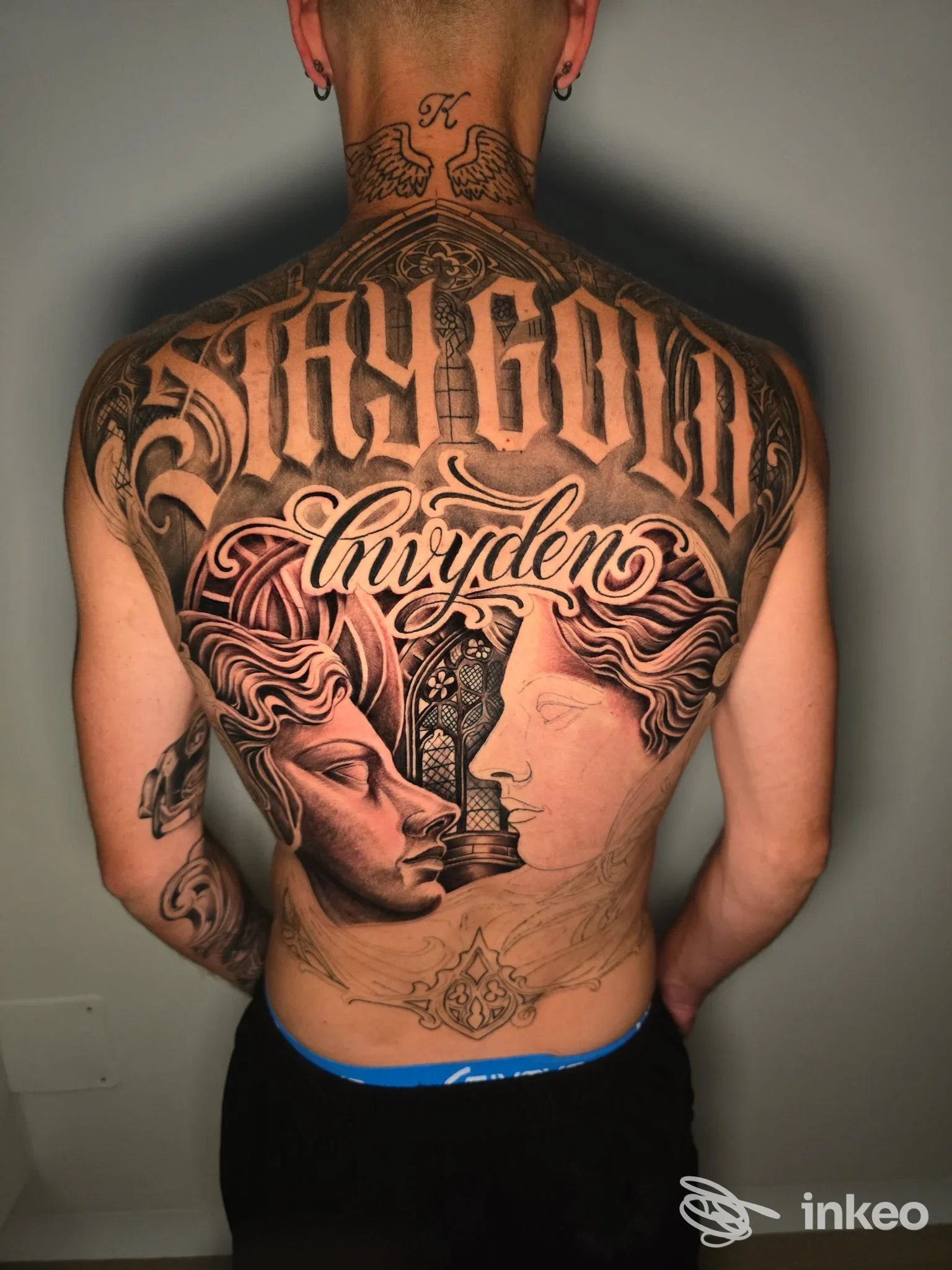 Grande tatuaggio sulla schiena con lettering 'STAY GOLD' e due profili realistici, lavoro esposto dallo studio DINO TATTOO a Molfetta.