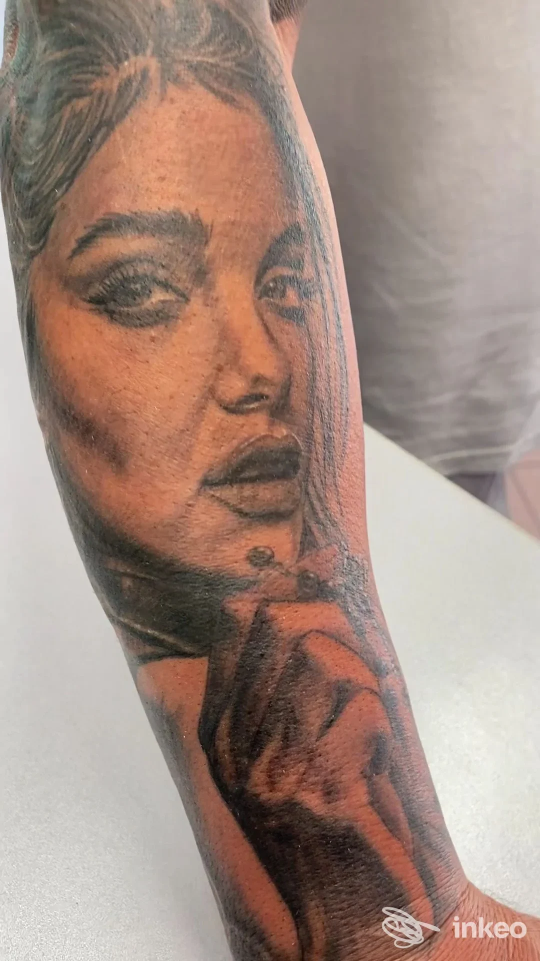 Tatuaggio realistico di volto femminile e mano su avambraccio, immagine fornita dallo studio THE GALLERY OF TATTOO DI TARTARI ANDREA a Cento.