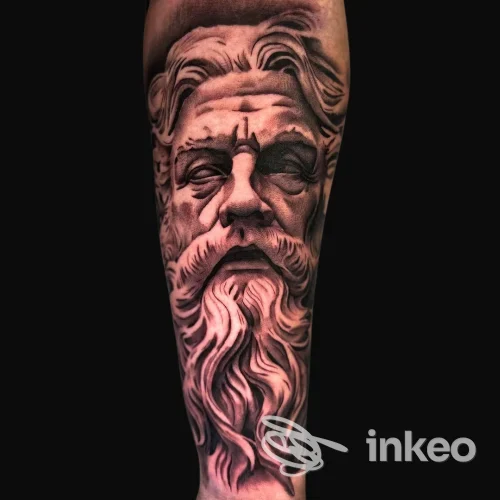 Tatuaggio realistico di volto scultoreo su avambraccio, foto fornita da Vicious Art Tattoo, Aprilia, dettaglio in bianco e nero su pelle.