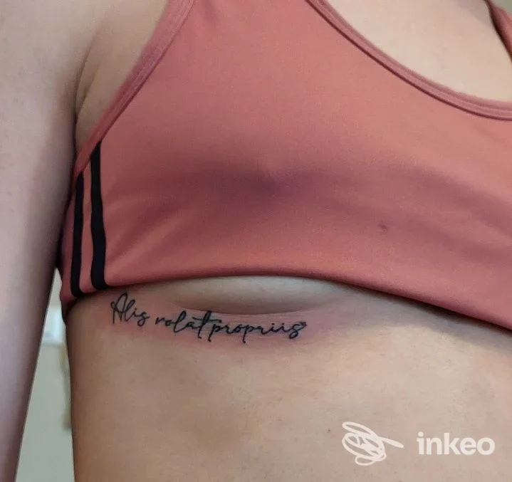 Tatuaggio in corsivo lungo la costa sotto il seno realizzato da Ehawee Estetica & AR Tattoo a Cento.