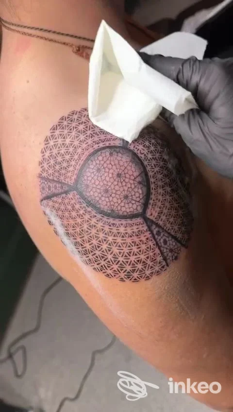 Tatuaggio geometrico dotwork sulla spalla realizzato da Noire Atelier a Bolzano, motivo circolare e reticolo decorativo.
