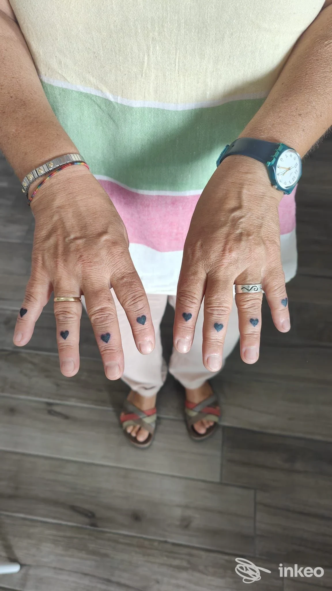 Mani con piccoli tatuaggi a forma di cuore sulle dita, fotografia del lavoro per Tattoo 9H1 Estetica Mails, Prato.