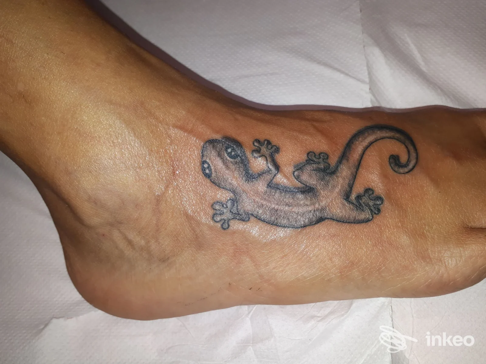 Tatuaggio di una lucertola in nero sul dorso del piede. Tattoo 9H1 Estetica Mails, Prato.