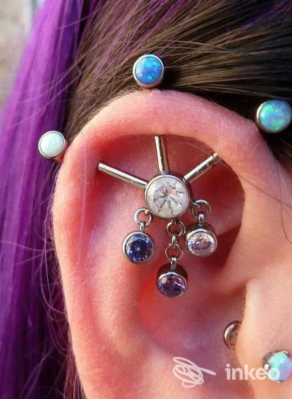 Primo piano di un orecchio con più piercing decorativi e pendenti, foto dal portfolio de Il Negozino di Di Gaetano Emanuela a Siena.