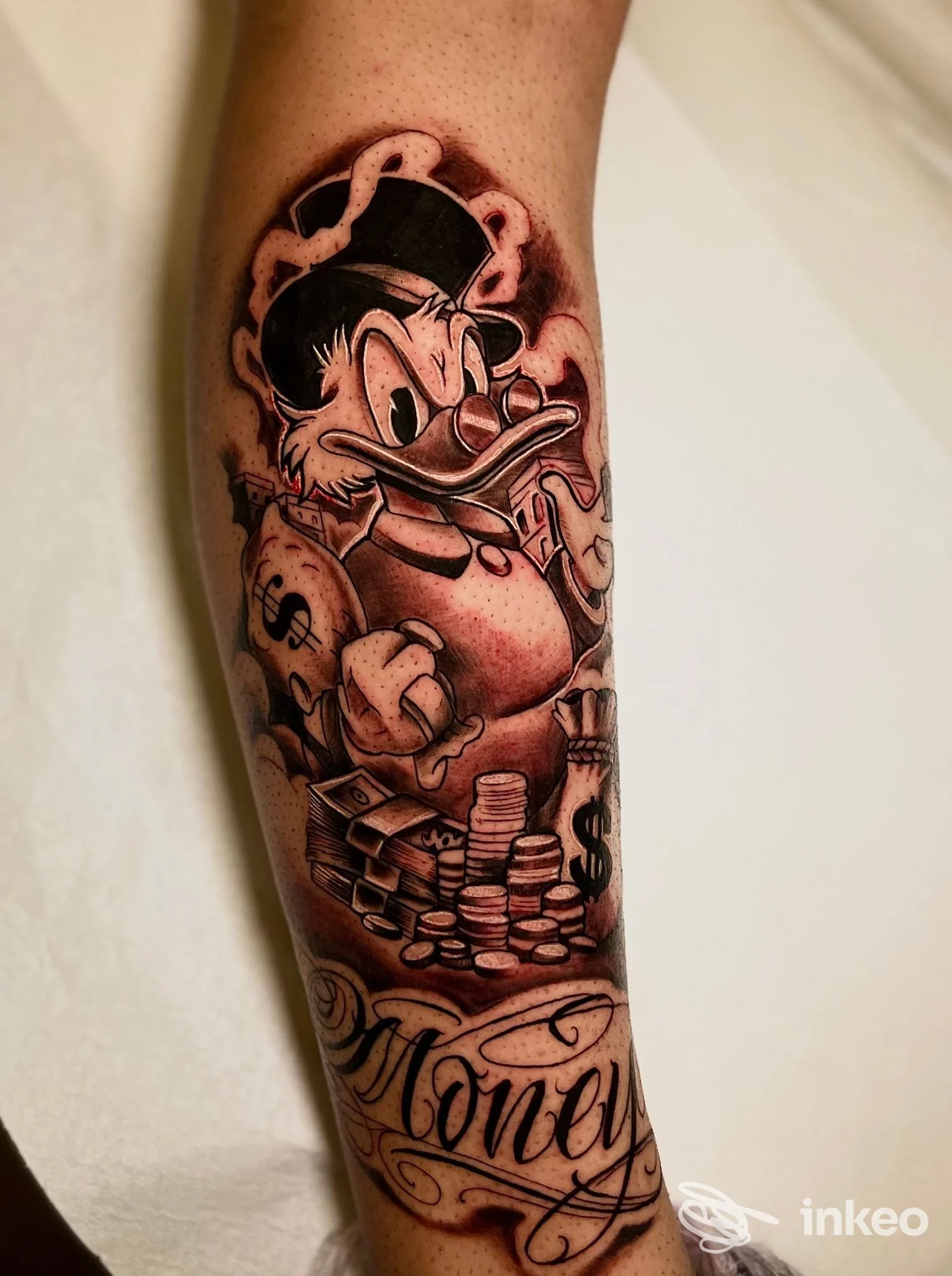 Tatuaggio sul avambraccio con personaggio cartoon, pile di monete e la scritta 'Money', realizzato da Ro barber tattoo a Lecce.
