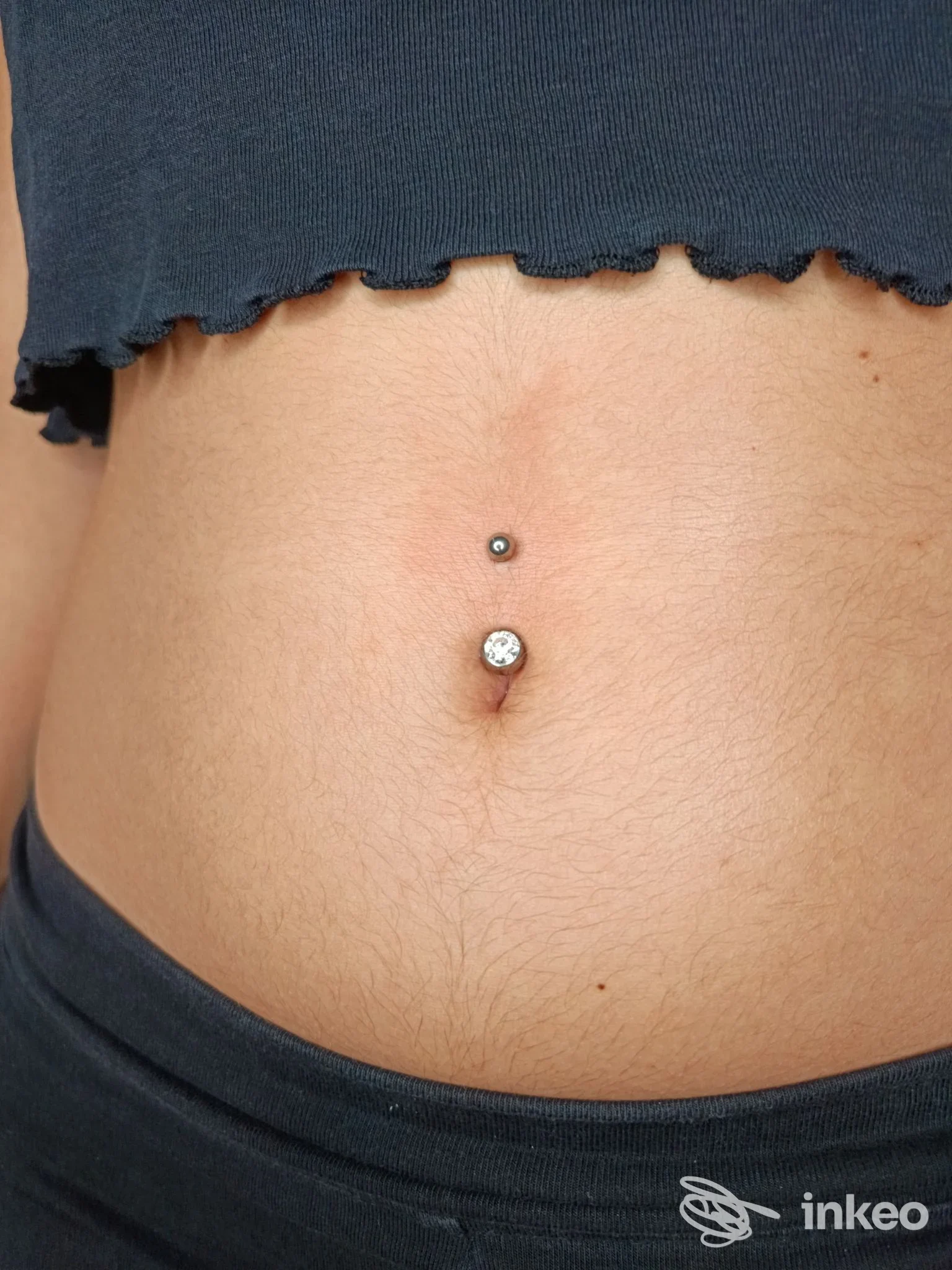 Primo piano di piercing ombelicale eseguito da Aurora Veleno Beauty Artist a Foggia, gioiello con pietra sul bordo dell'ombelico.