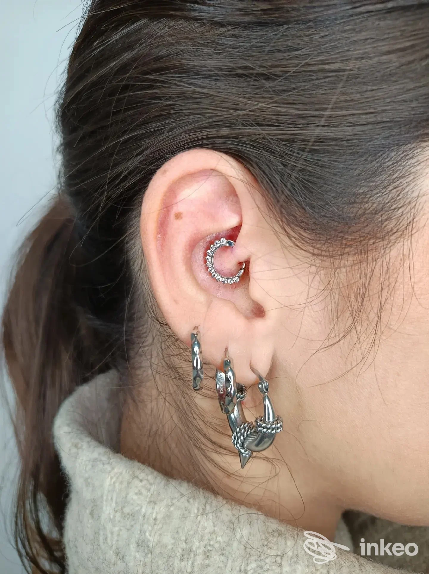 Primo piano di orecchio con vari piercing e gioielli, scatto per Aurora Veleno Beauty Artist a Foggia.